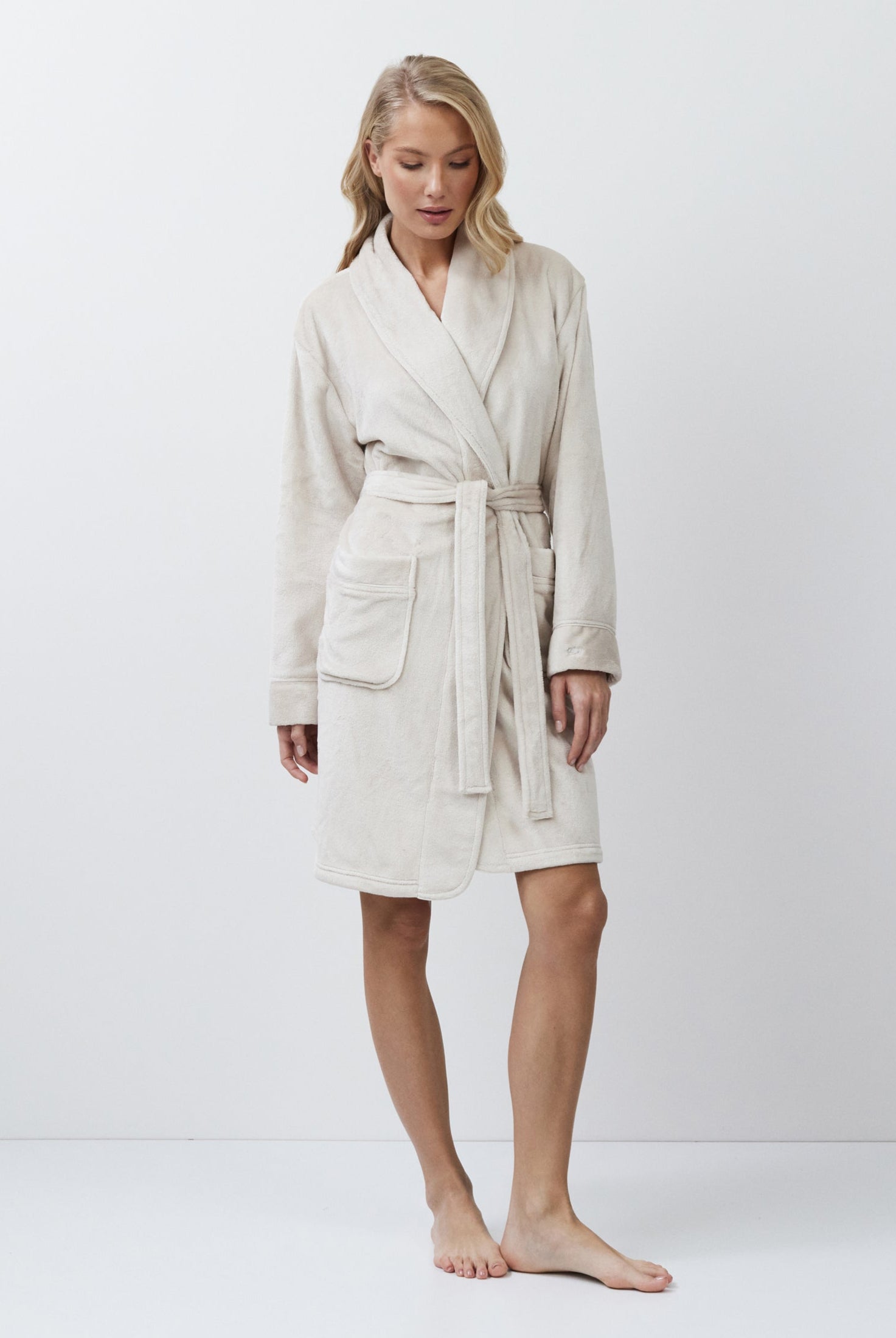Woman wearing a beige robe against a white background