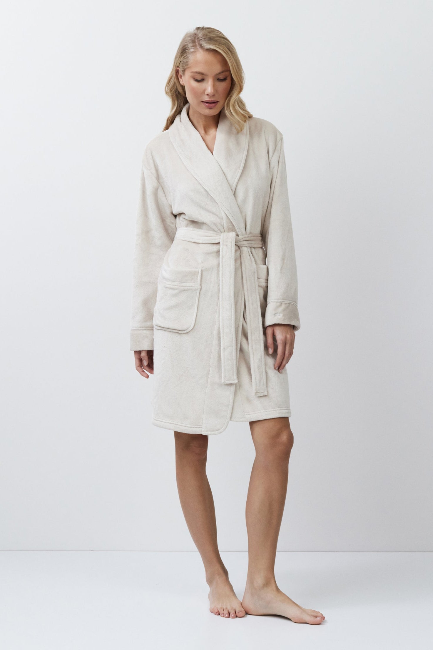 Woman wearing a beige robe against a white background