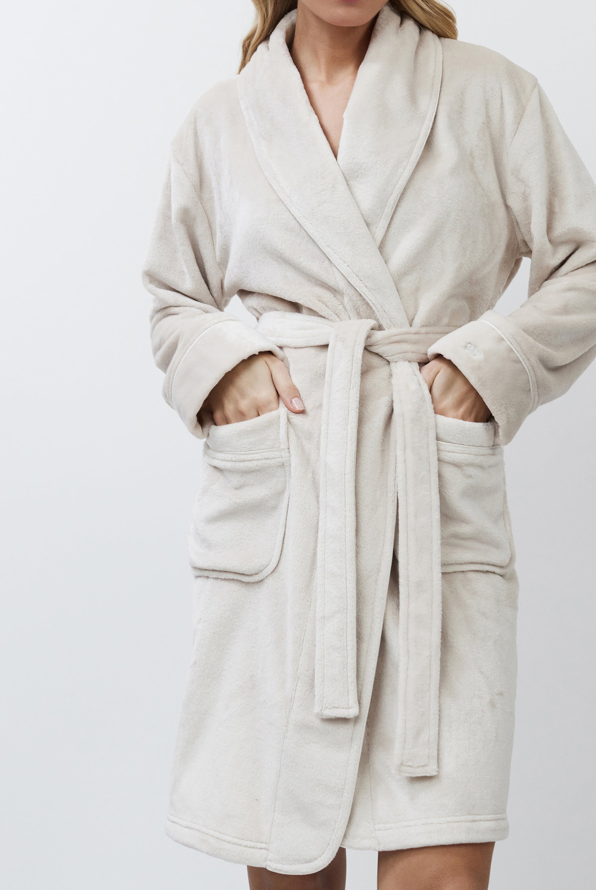 Beige bathrobe worn by a person on a white background