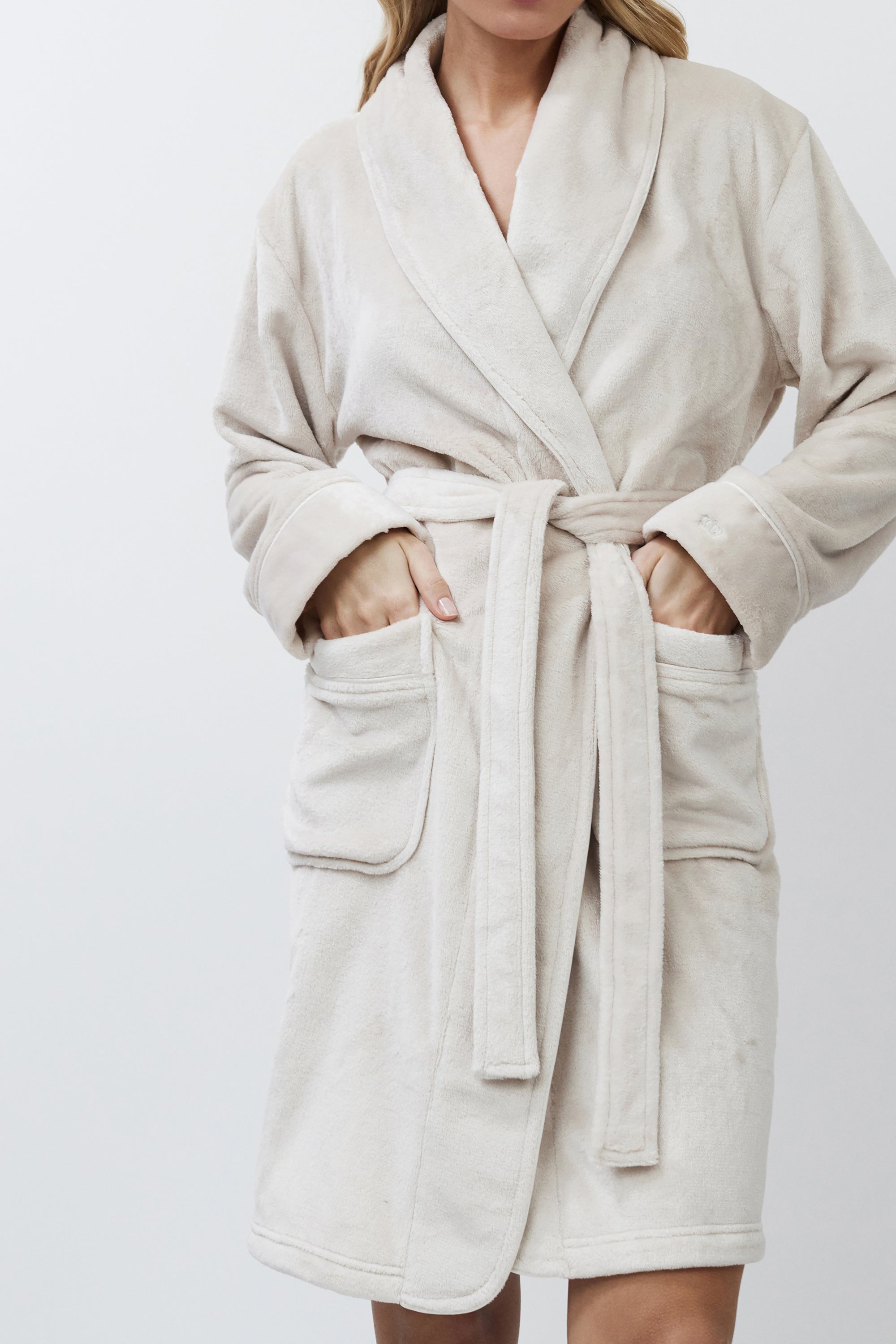 Beige bathrobe worn by a person on a white background
