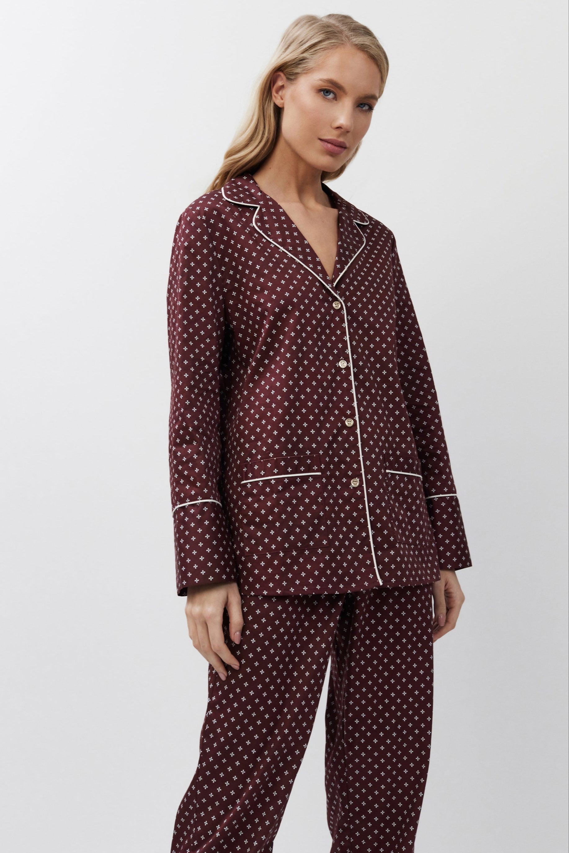 Woman wearing a burgundy pajama set on a white background