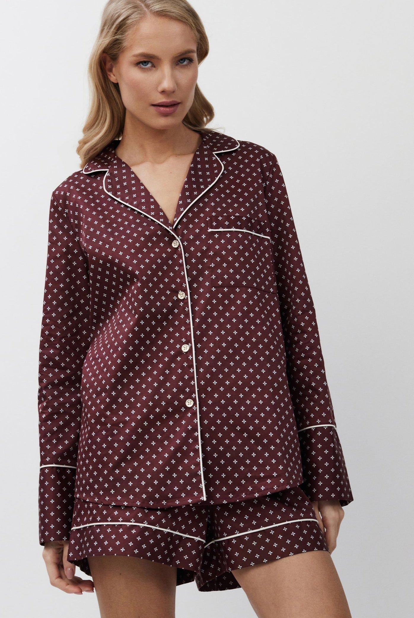 Woman wearing a burgundy pajama set on a white background