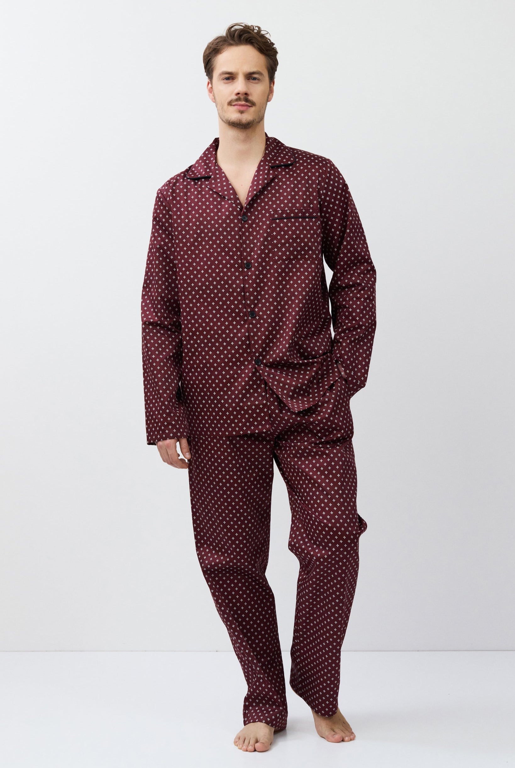 Man wearing a burgundy pajama set on a white background