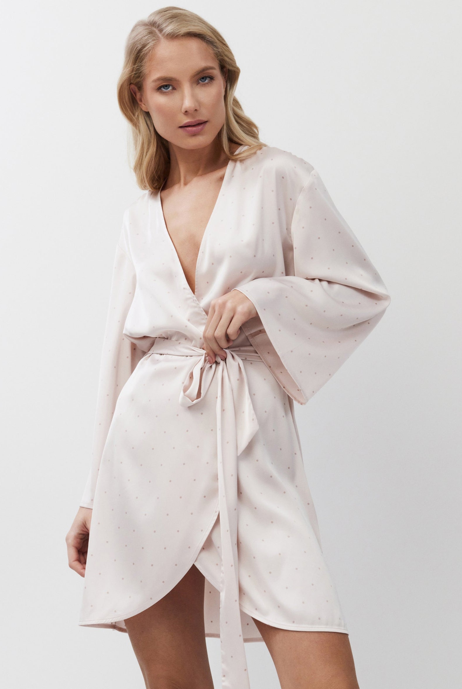 Woman wearing a light pink gown against a white background