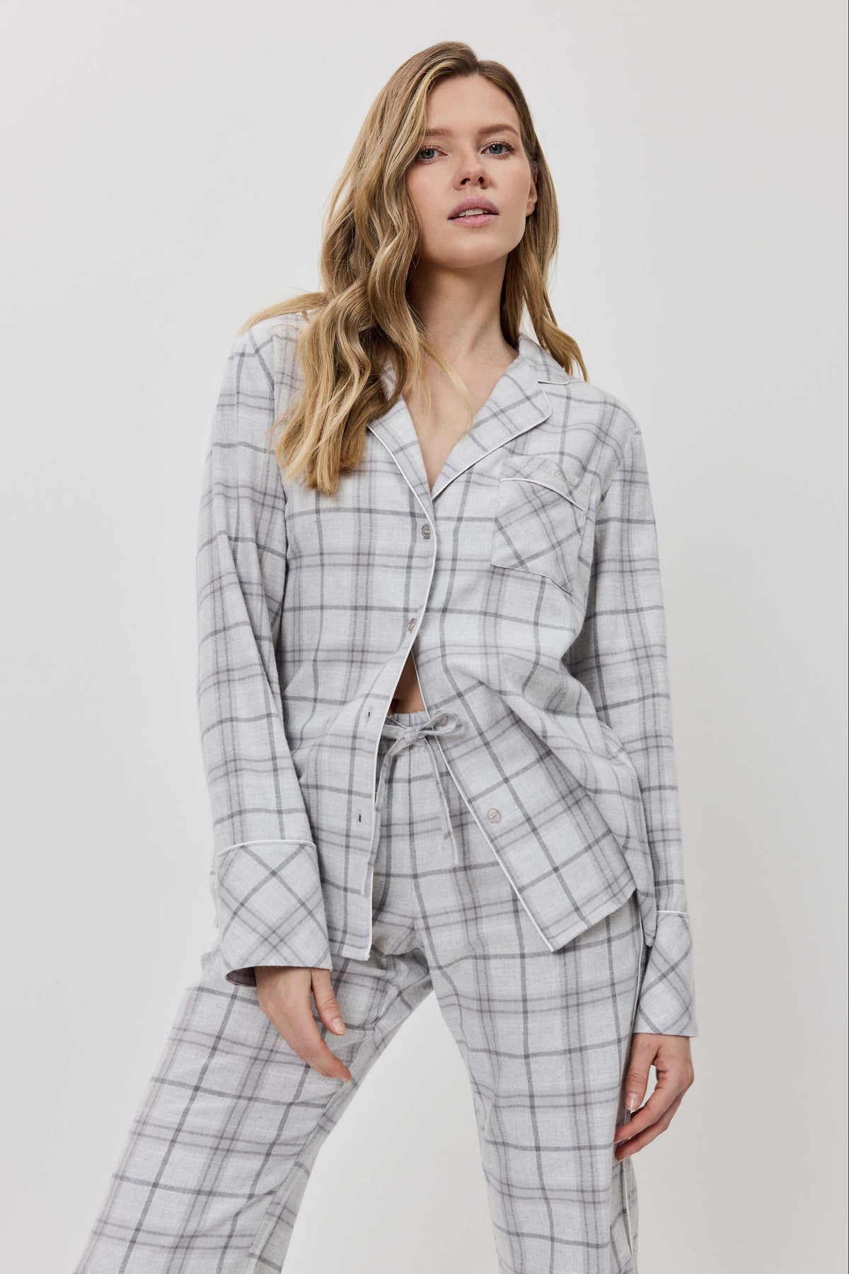 Woman wearing a gray checkered suit against a white background