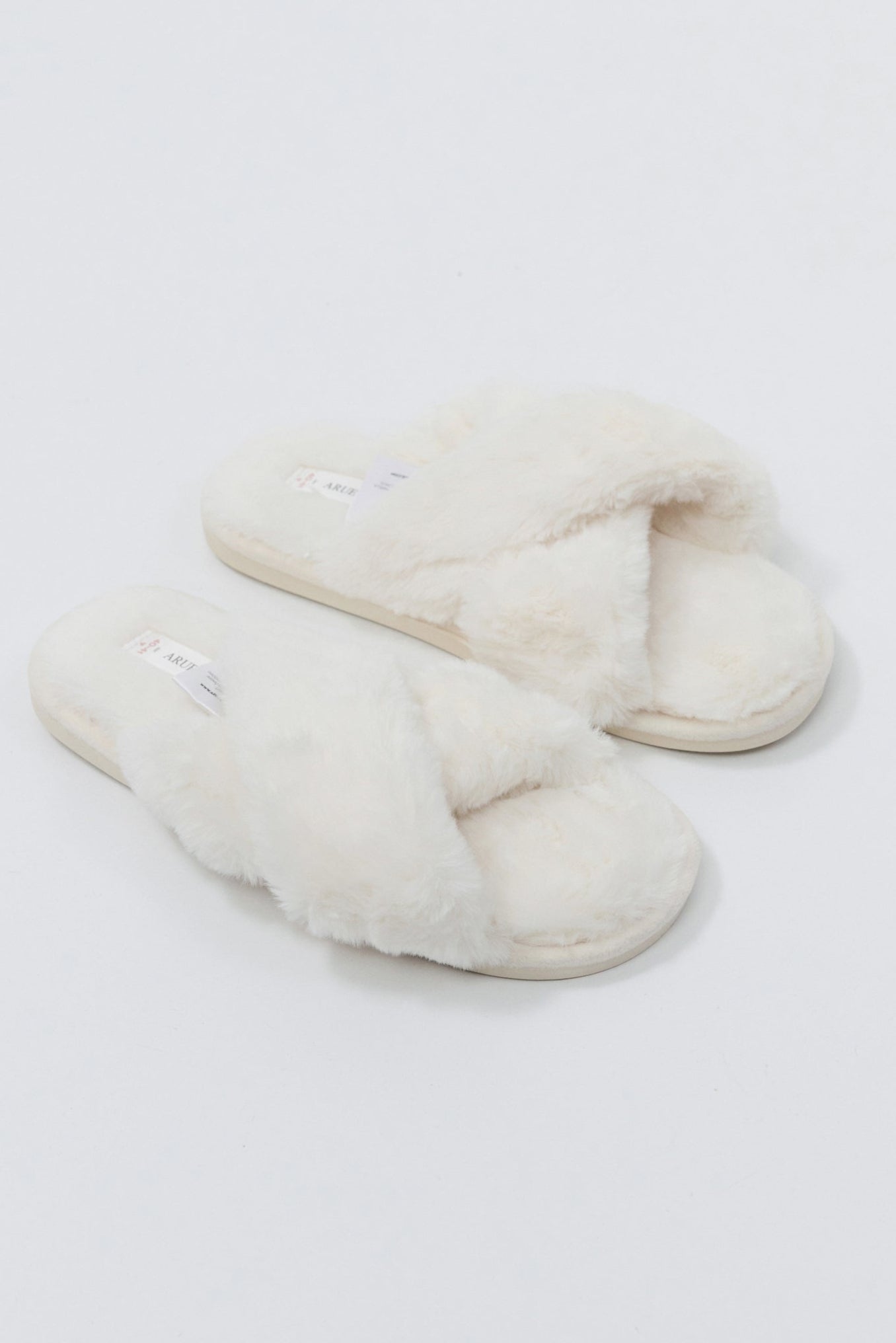 Pair of white slippers on a light gray background