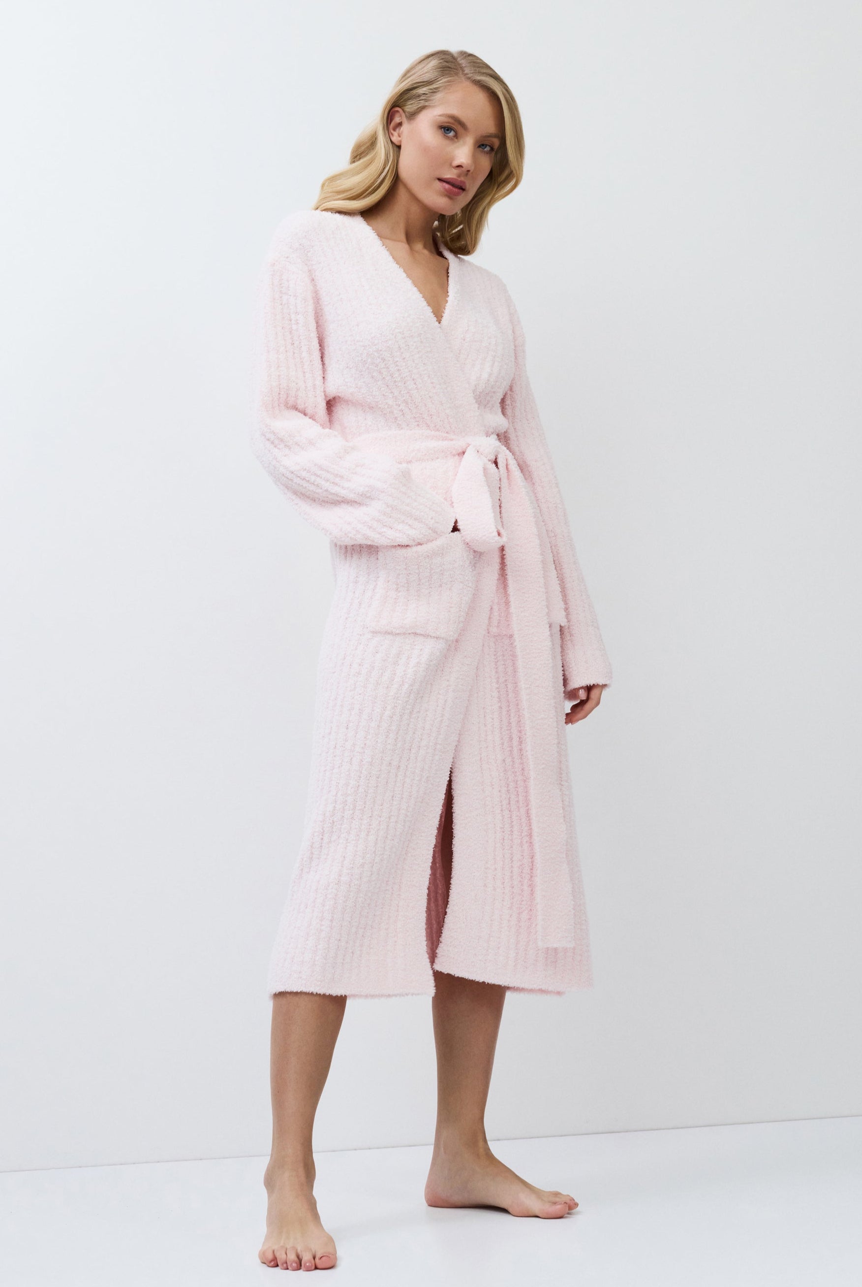 Woman wearing a pink bathrobe against a white background