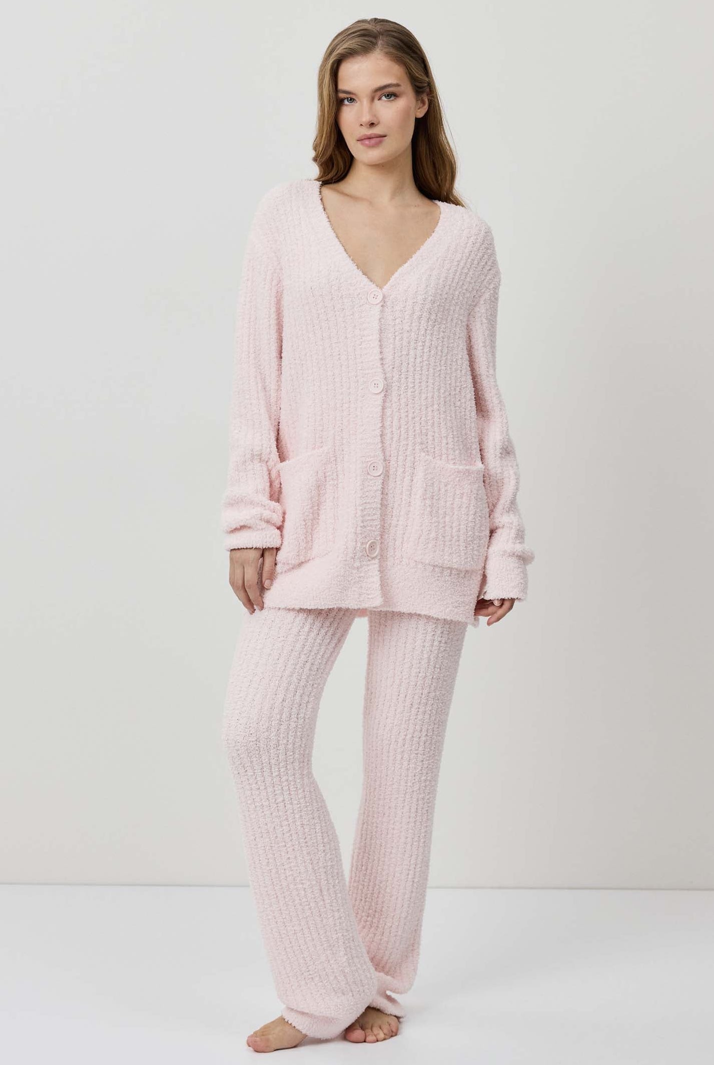 A woman wearing a light pink ribbed knit lounge set.