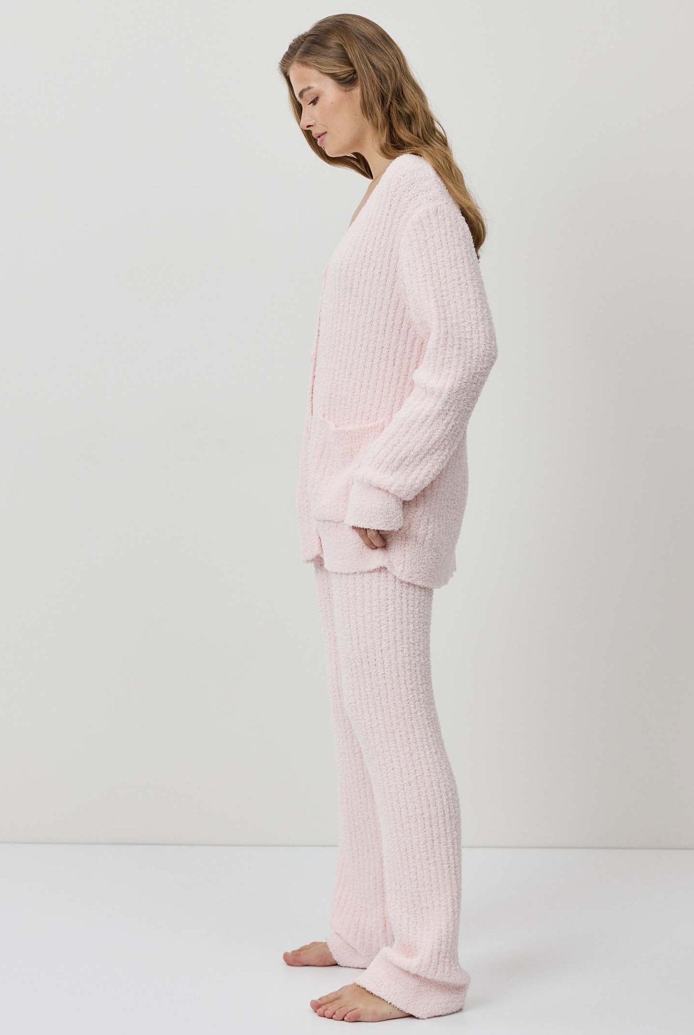 A woman wearing a light pink ribbed knit lounge set.