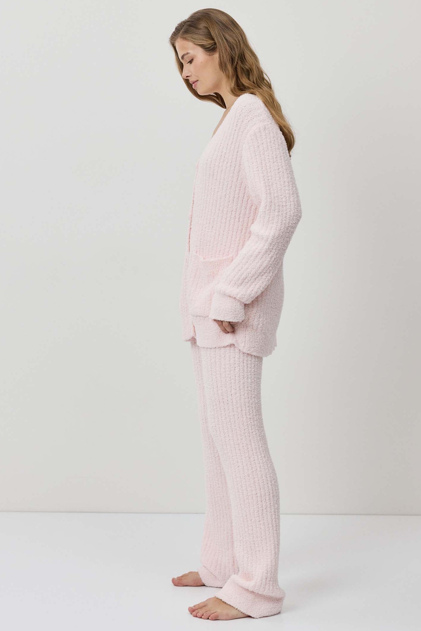 A woman wearing a light pink ribbed knit lounge set.