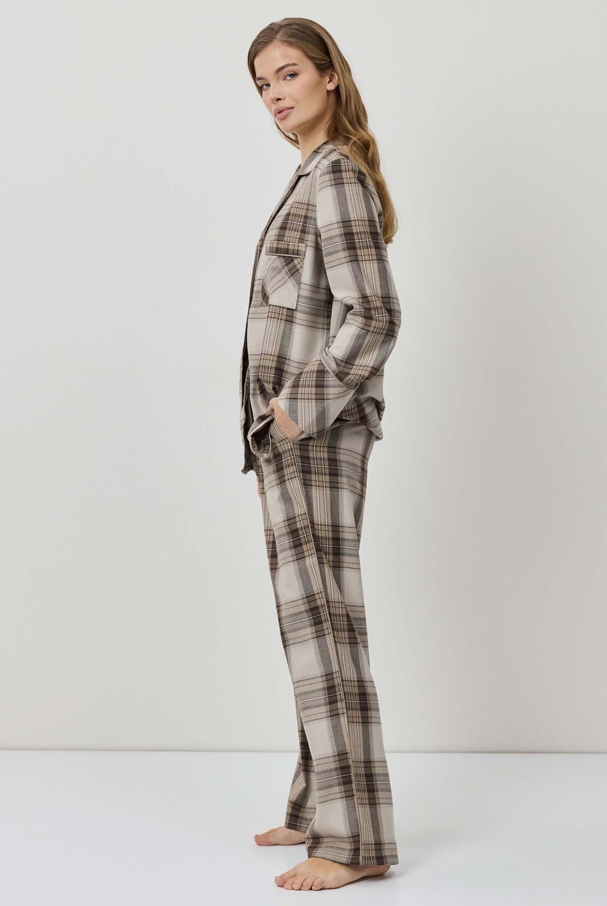 Woman wearing a plaid pajama set against a white background