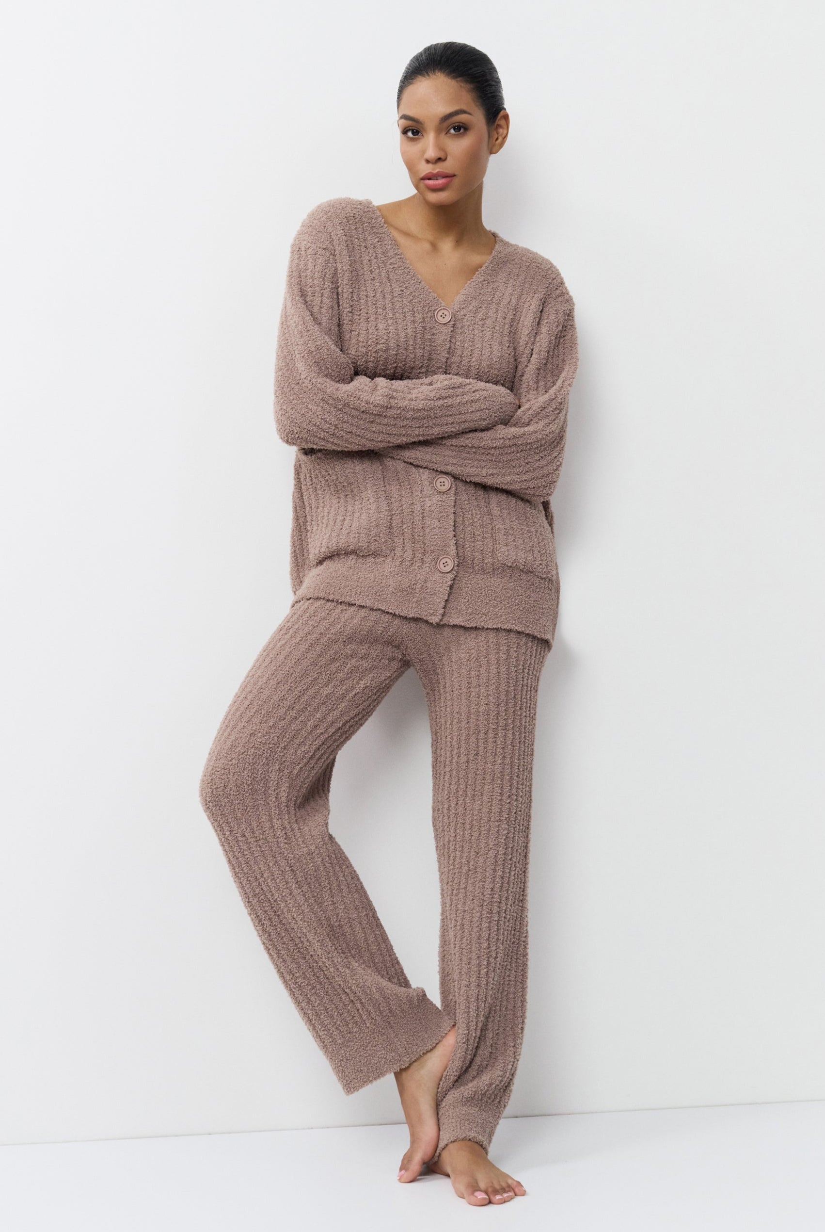 Woman wearing a brown ribbed knit set against a white background