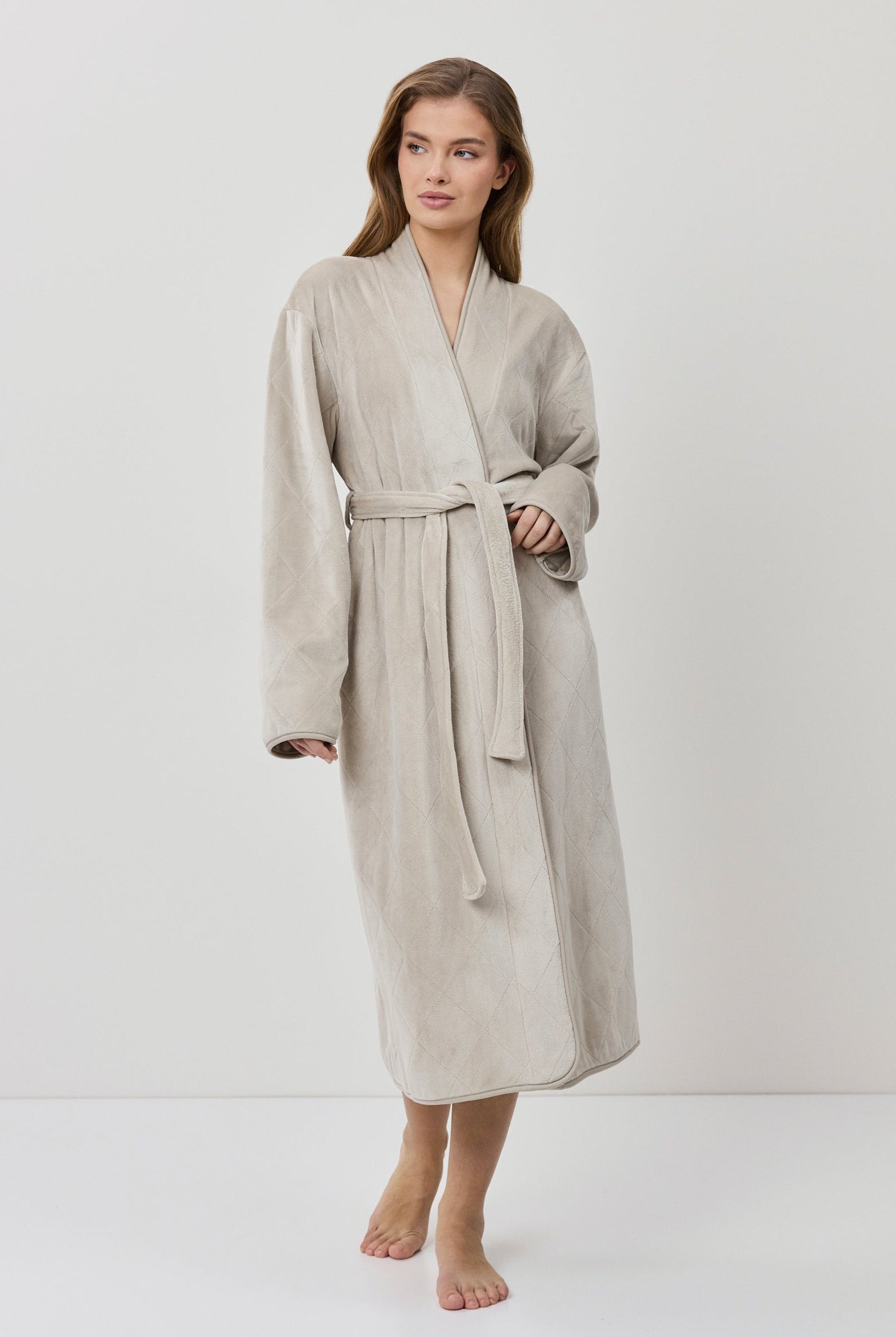 Woman wearing a beige robe on a white background