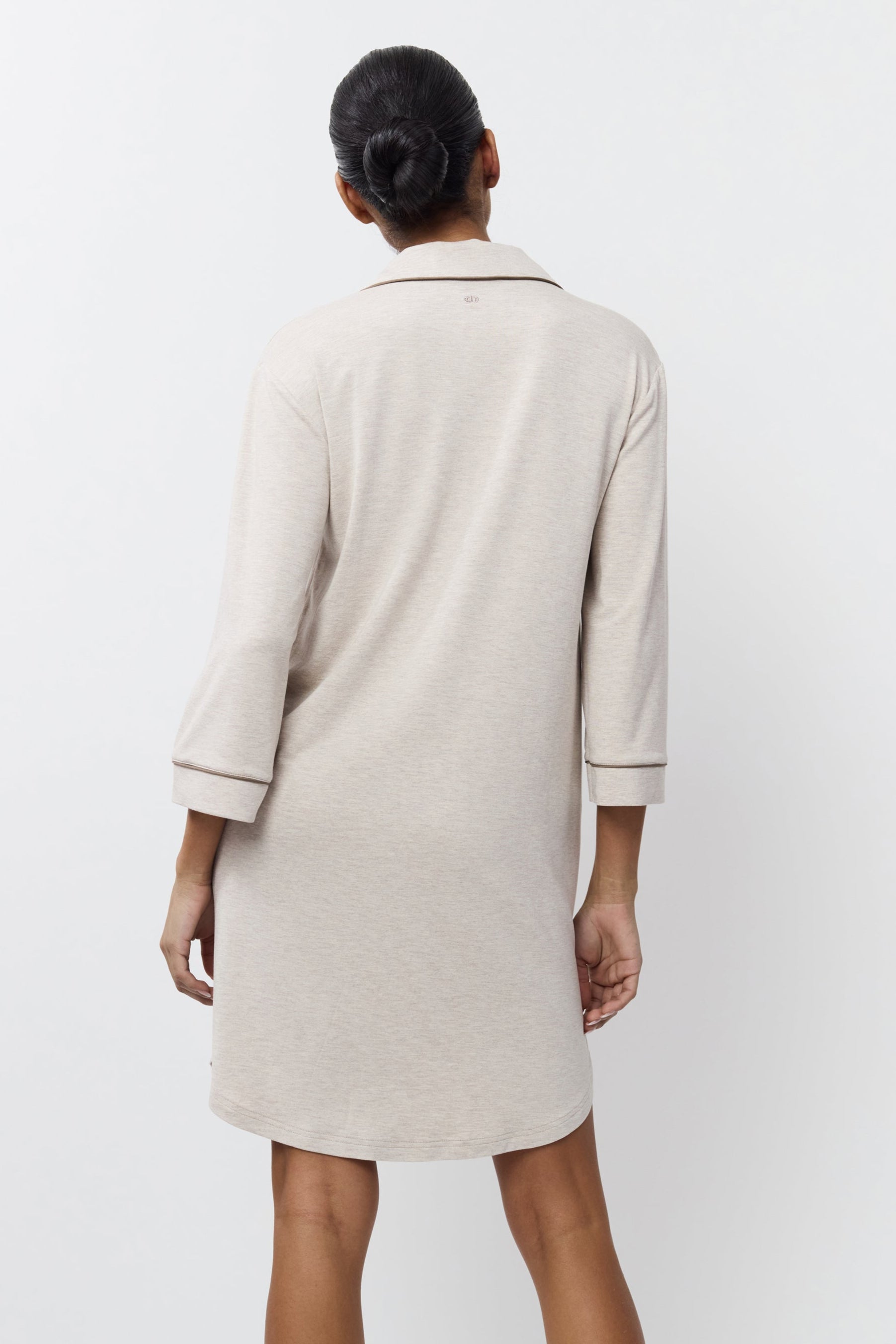 Woman wearing a beige nightdress against a white background