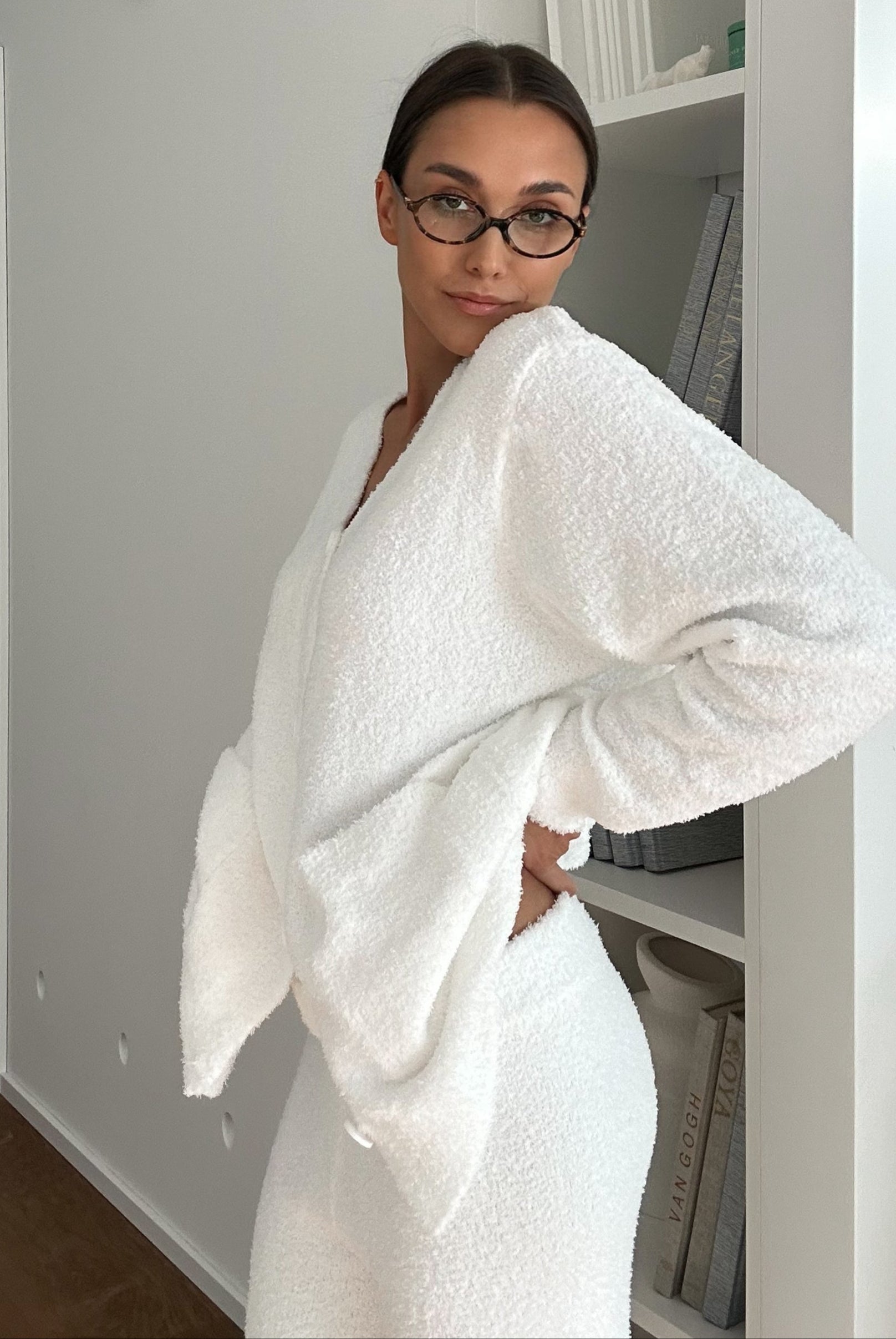 Woman wearing a white textured set in a minimalistic room.