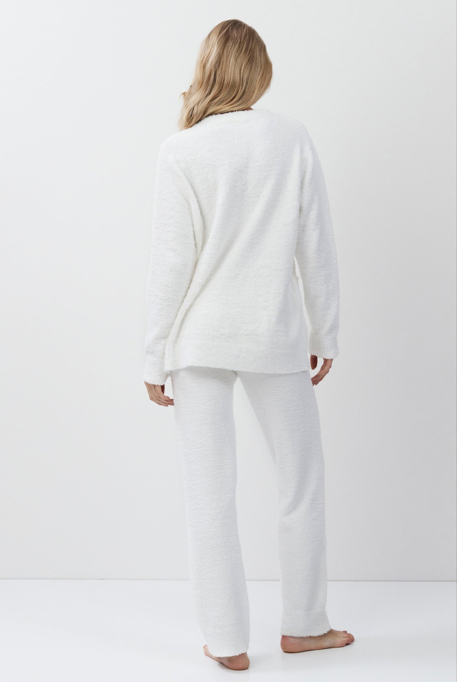 Person wearing a white loungewear set standing against a plain white background