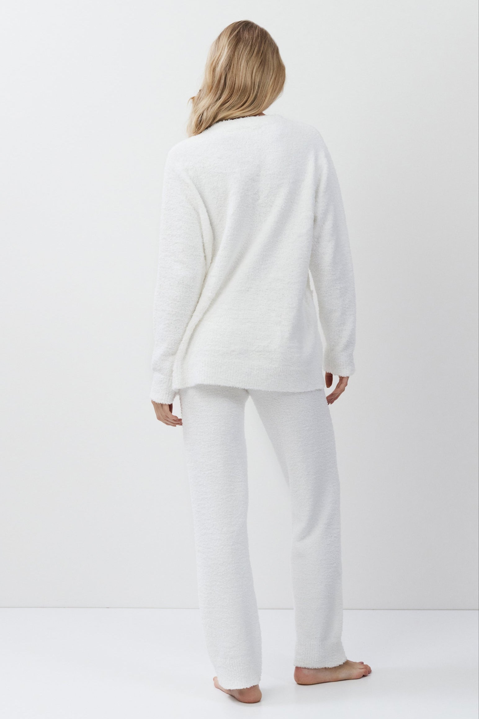 Person wearing a white loungewear set standing against a plain white background
