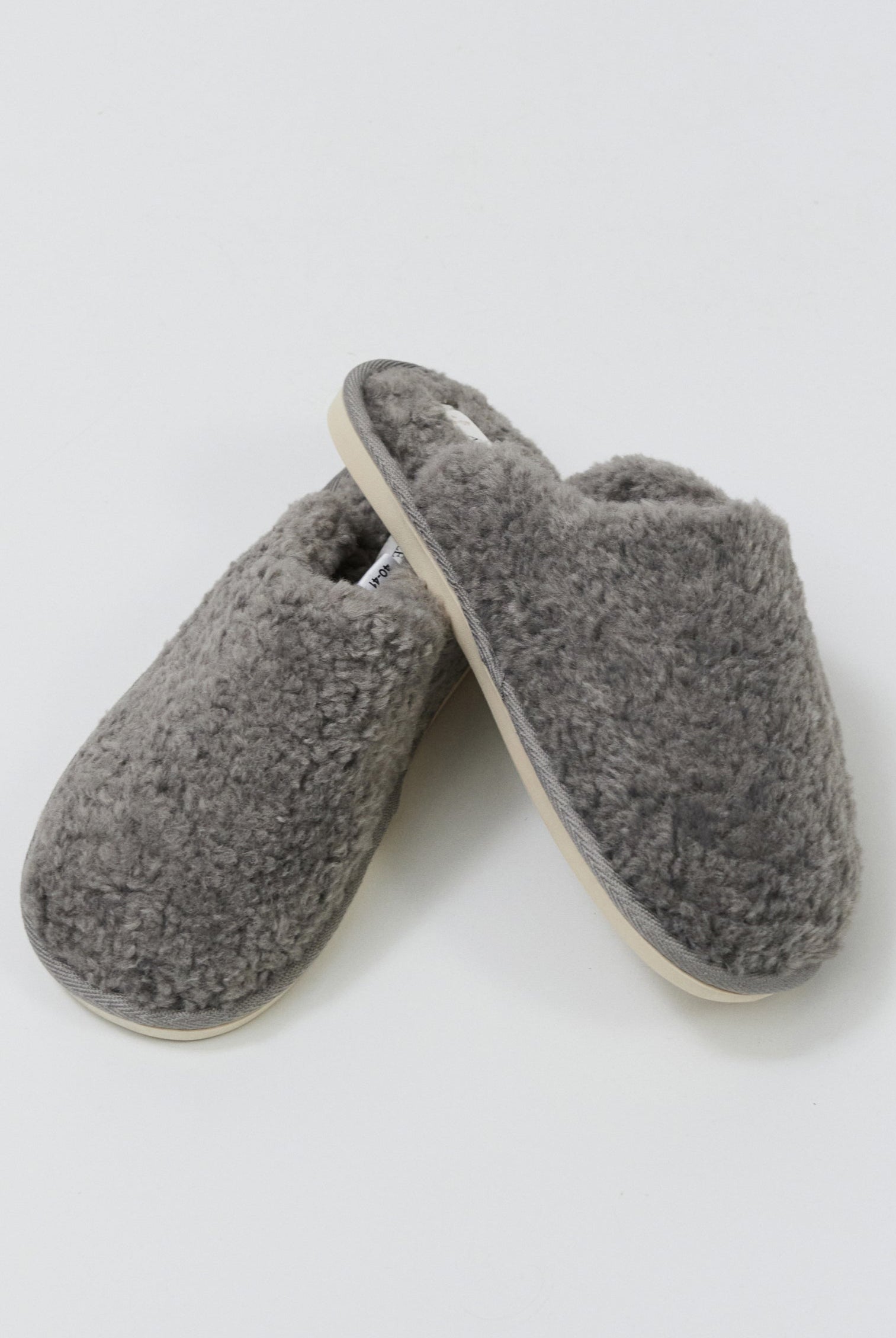 Pair of gray slippers on a light gray background