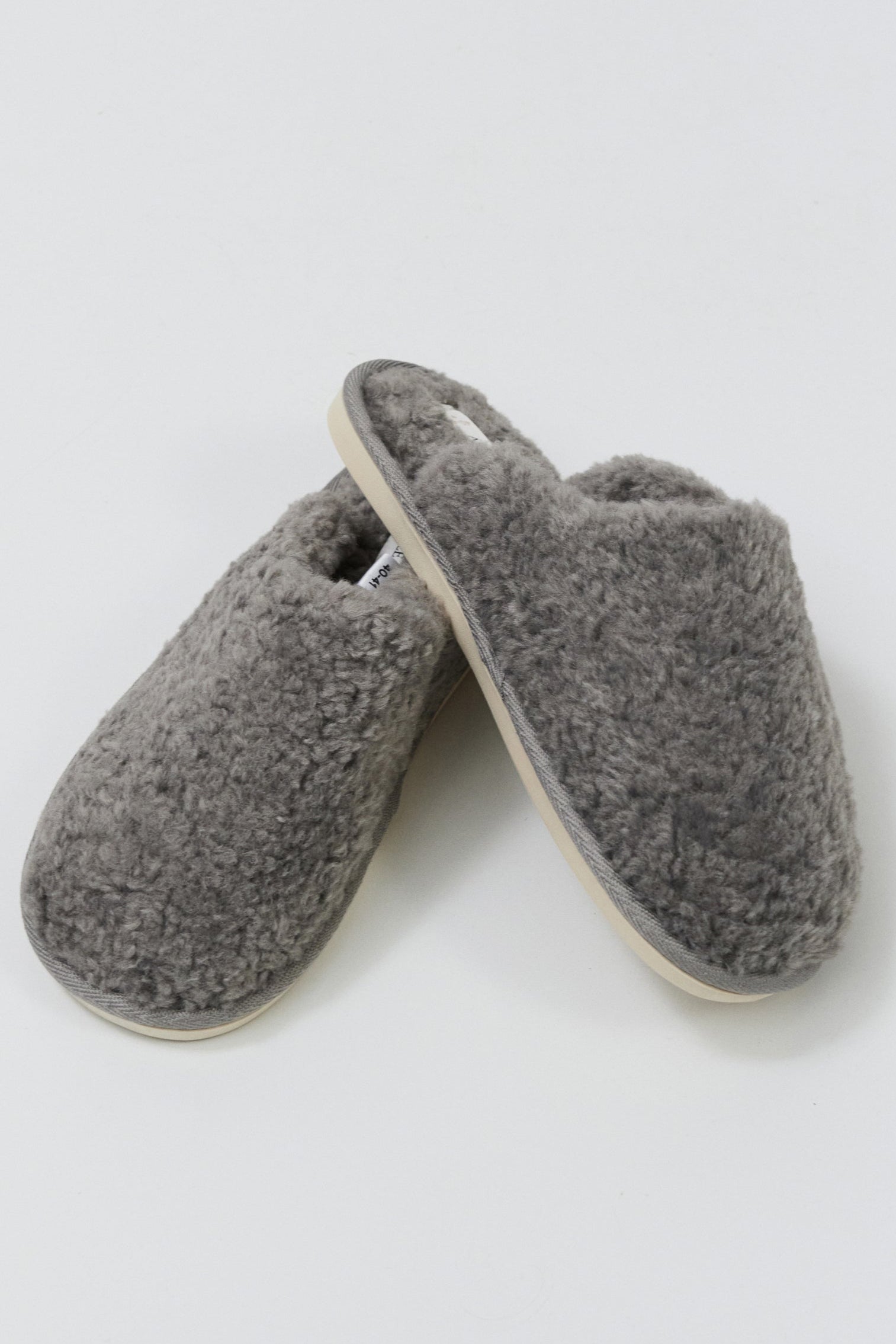 Pair of gray slippers on a light gray background