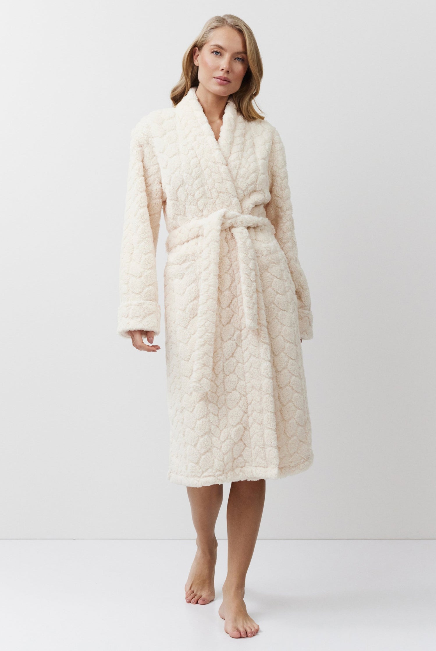 Woman wearing a cream-colored bathrobe on a white background