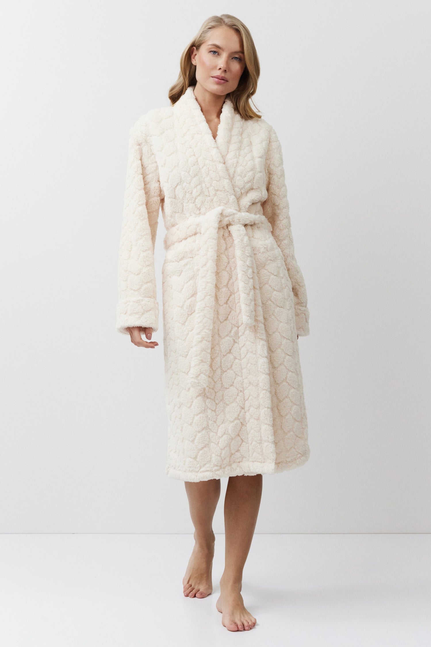 Woman wearing a cream-colored bathrobe on a white background