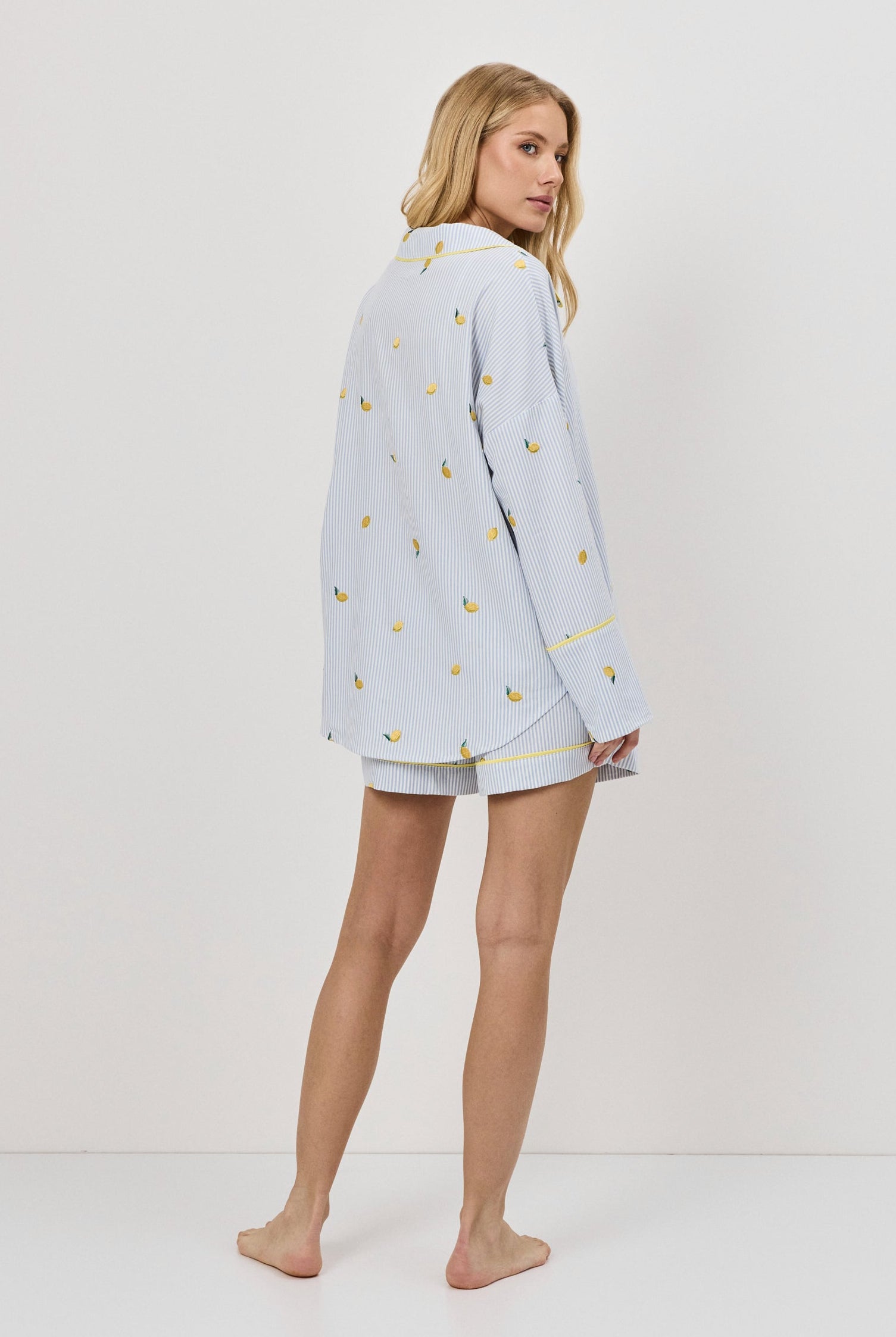 Woman wearing a light blue pajama set with a white background