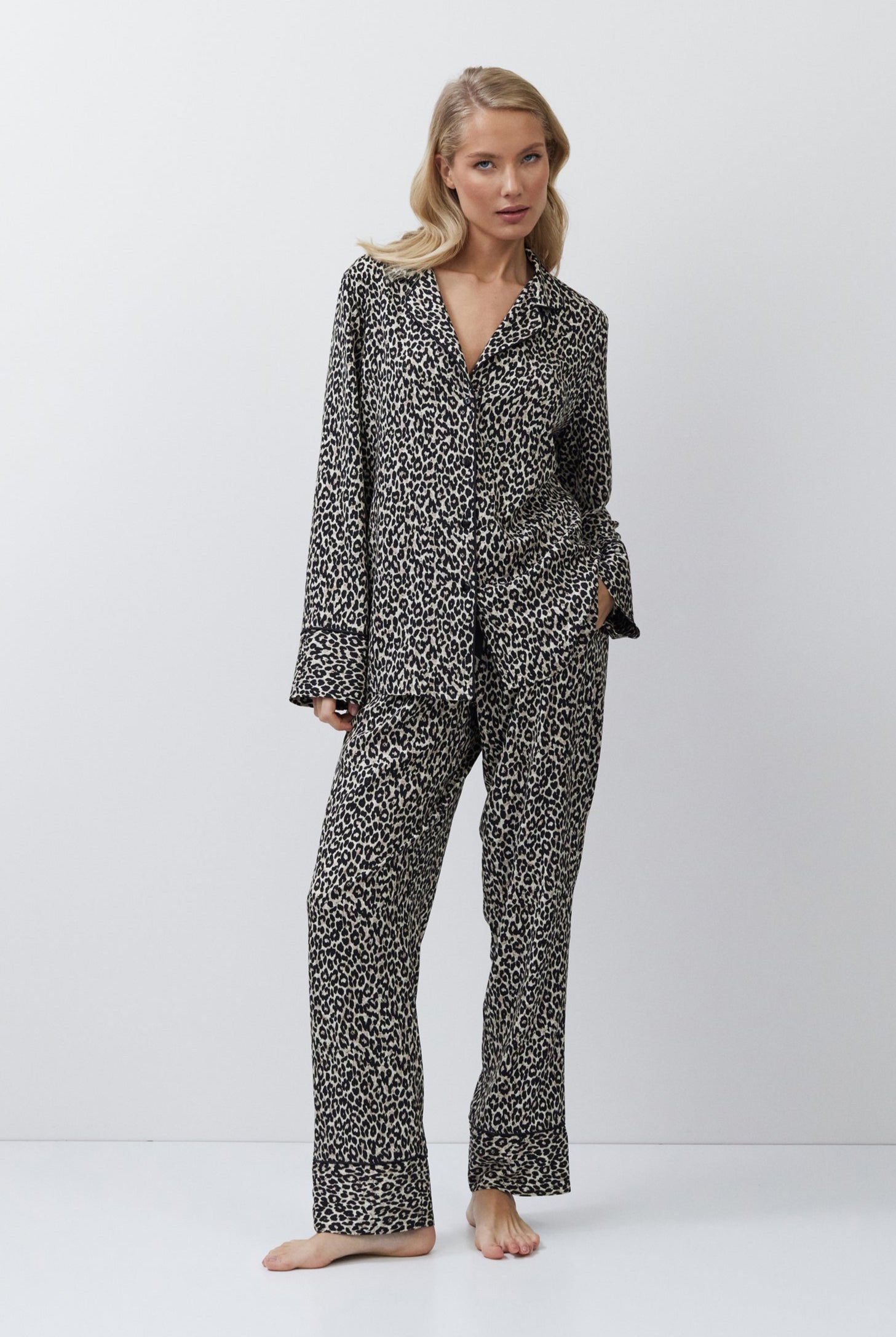 Woman wearing a leopard patterned pajama set on a white background