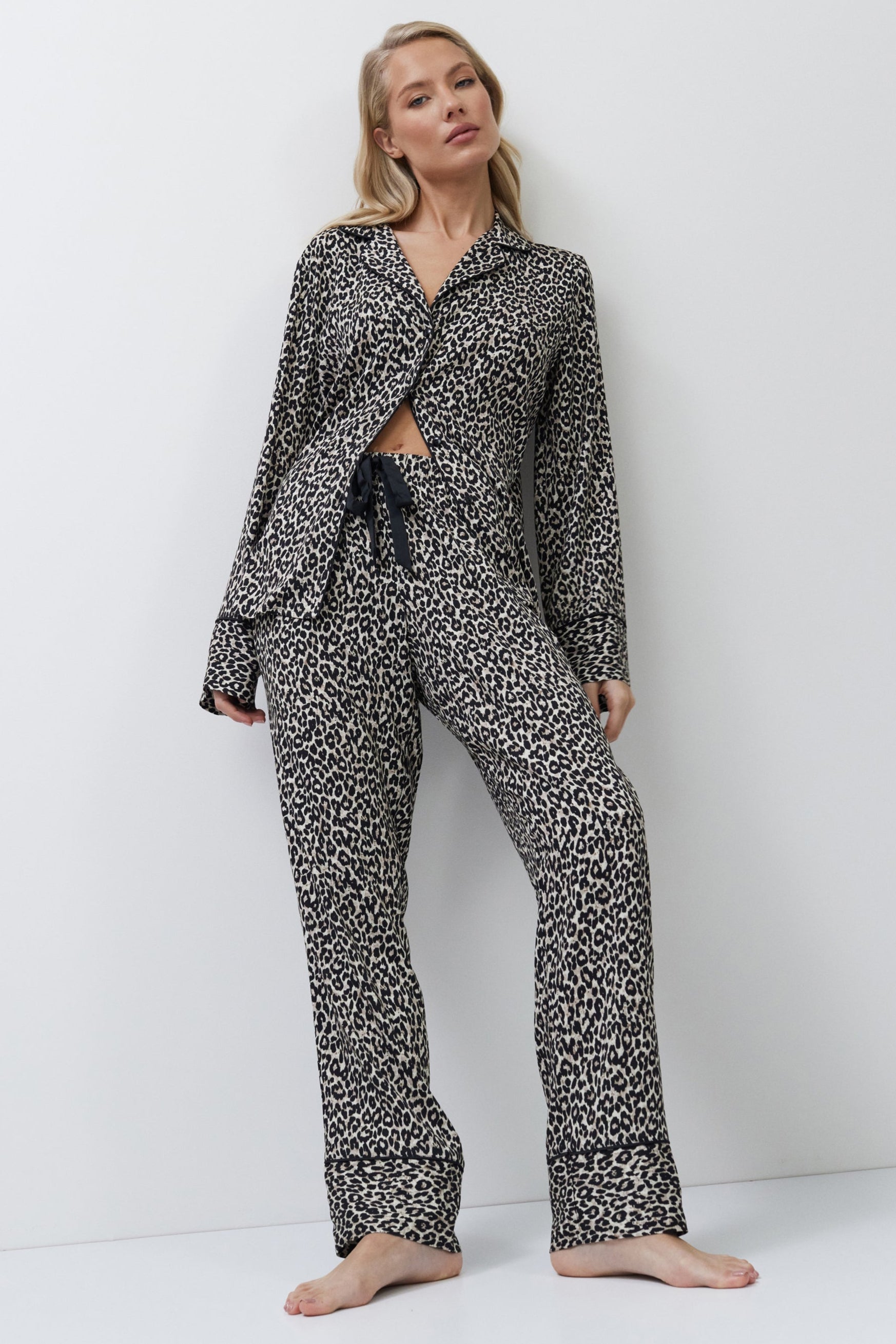Woman wearing a leopard patterned pajama set on a white background