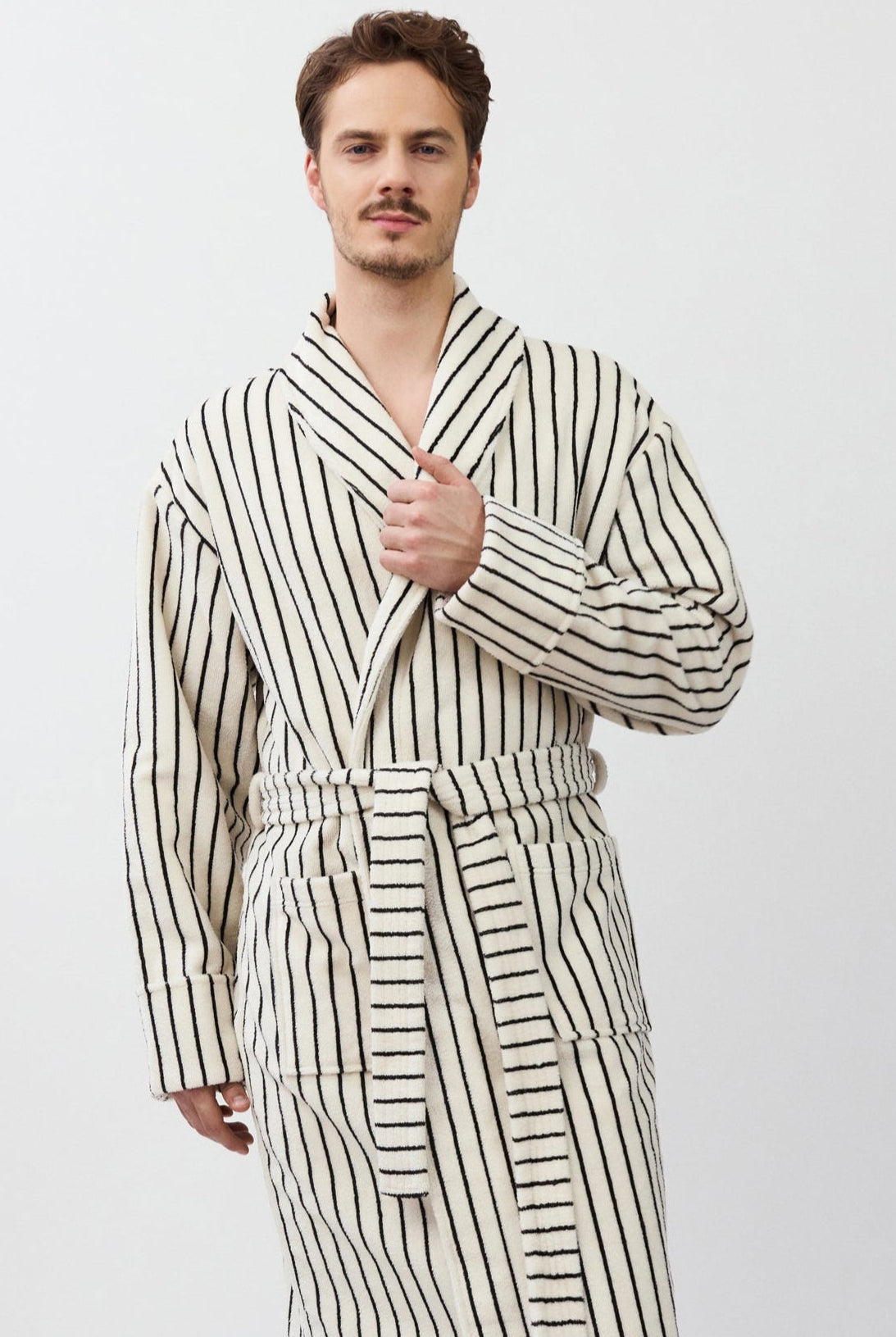 Man wearing a striped bathrobe on a white background