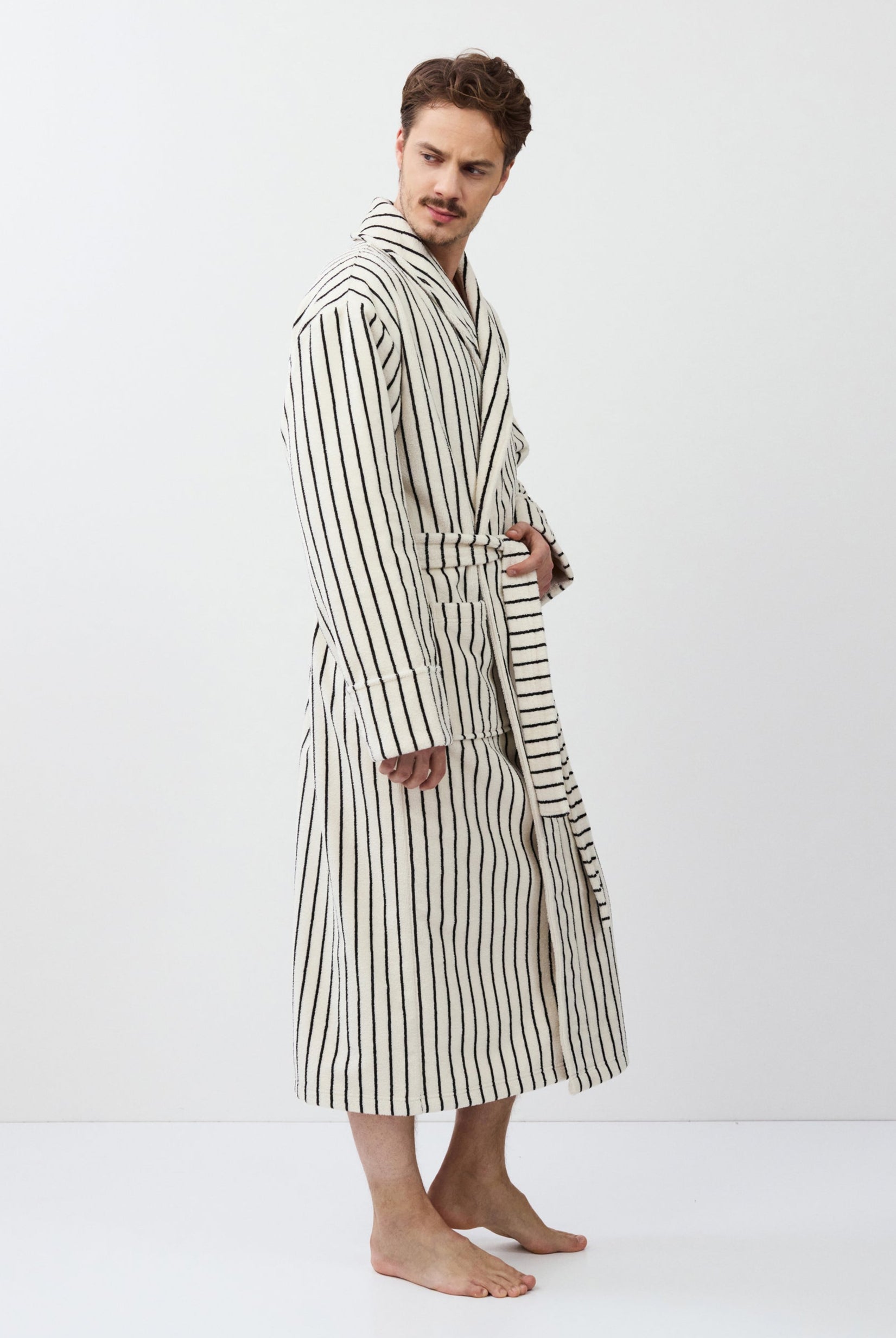 Man wearing a striped bathrobe against a white background