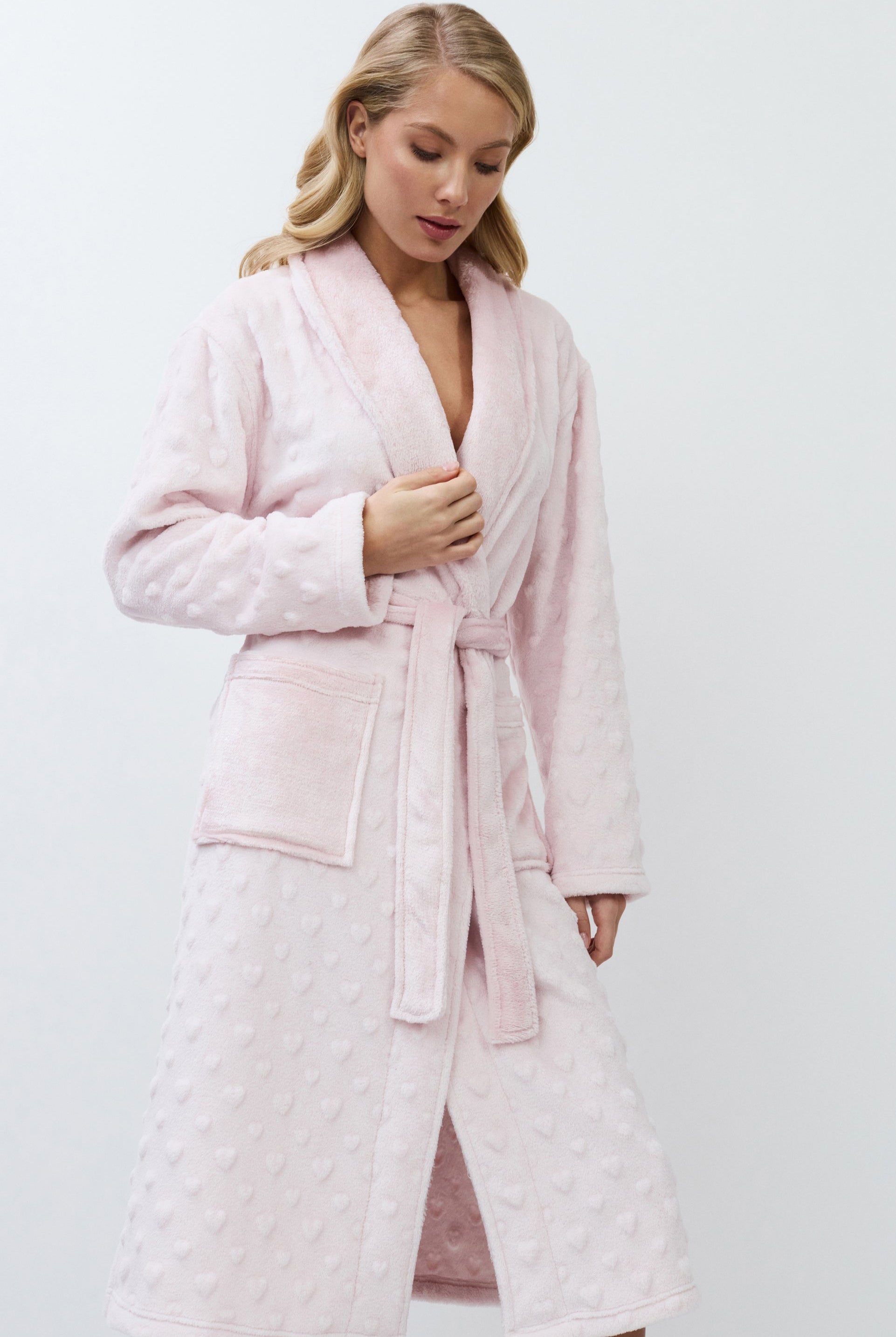 Woman wearing a pink athrobe against a white background