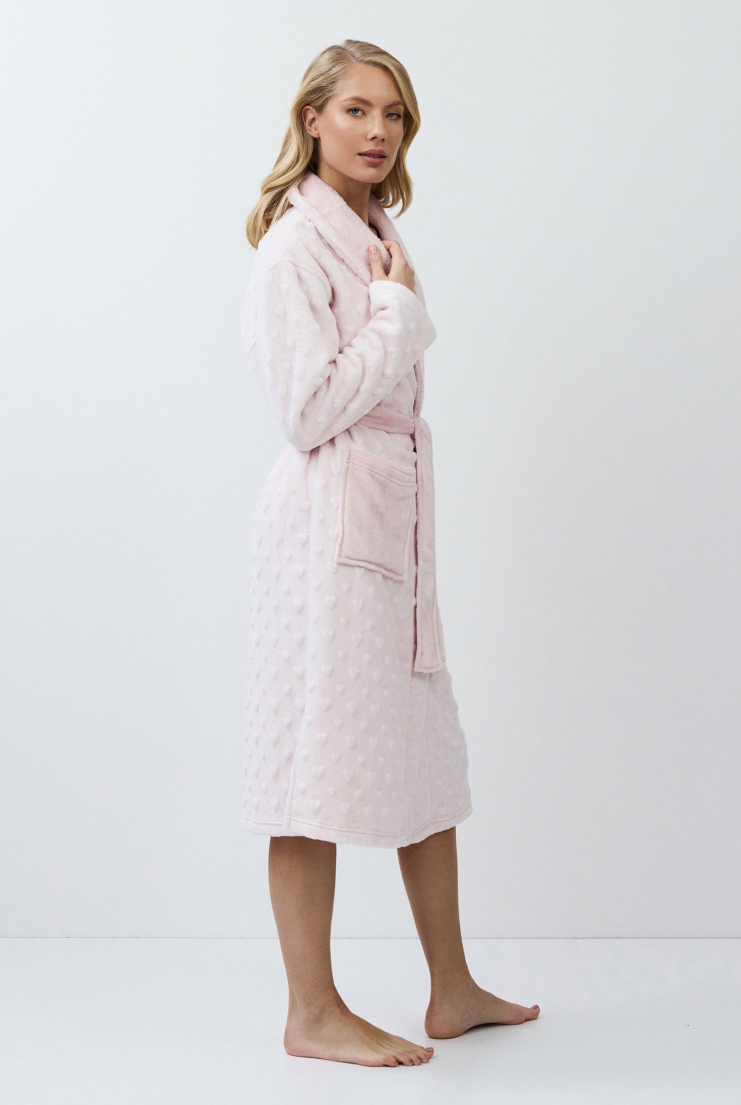 Woman wearing a pink quilted bathrobe on a white background