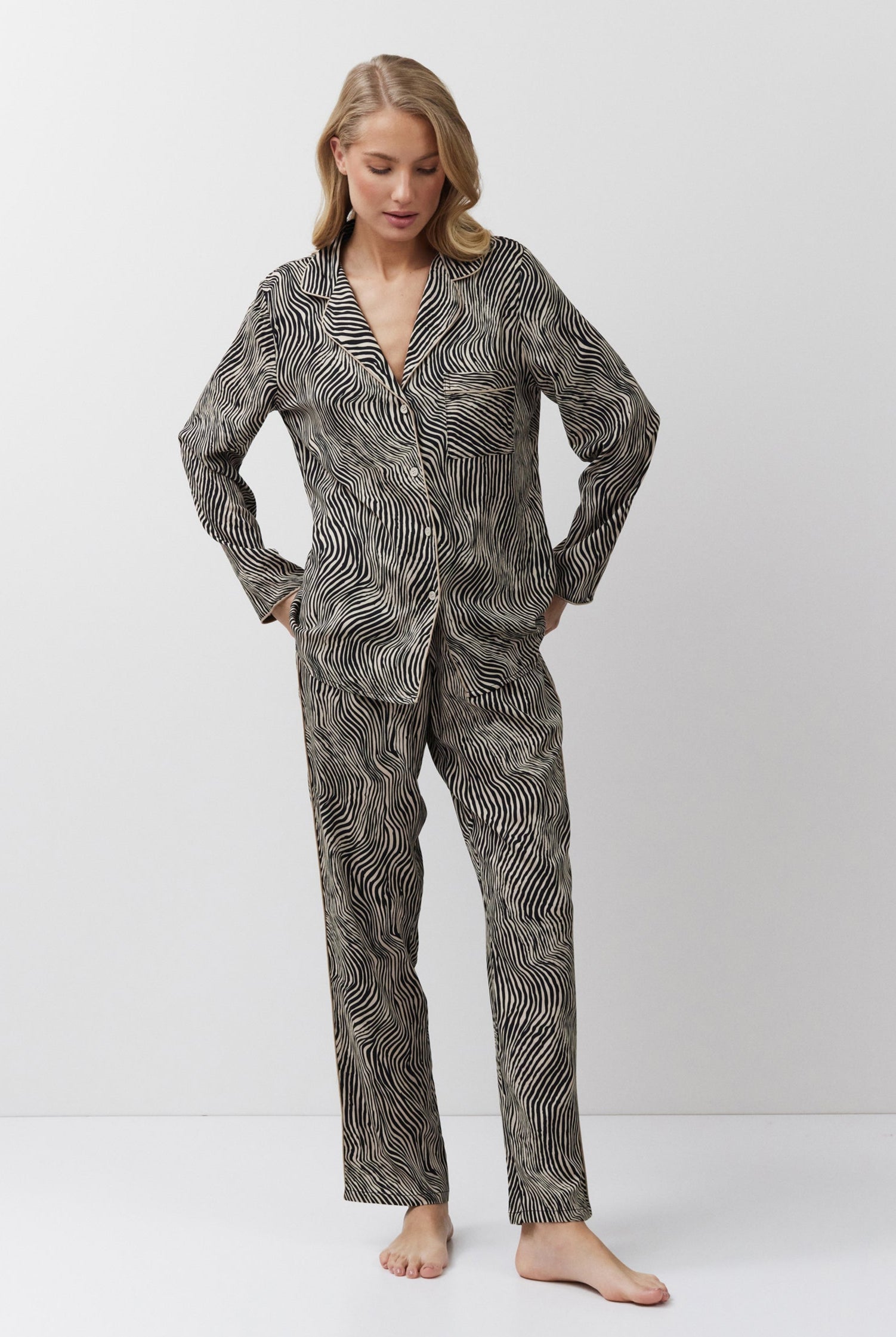 Woman wearing a patterned pajama set on a white background