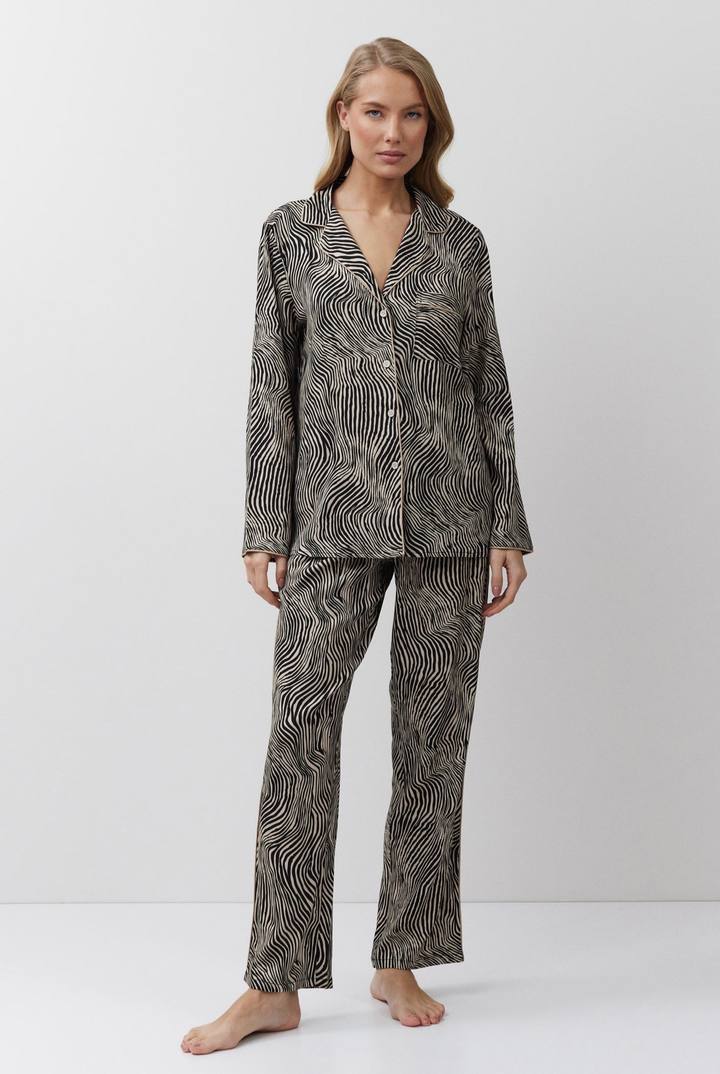 Woman wearing a patterned pajama set on a white background