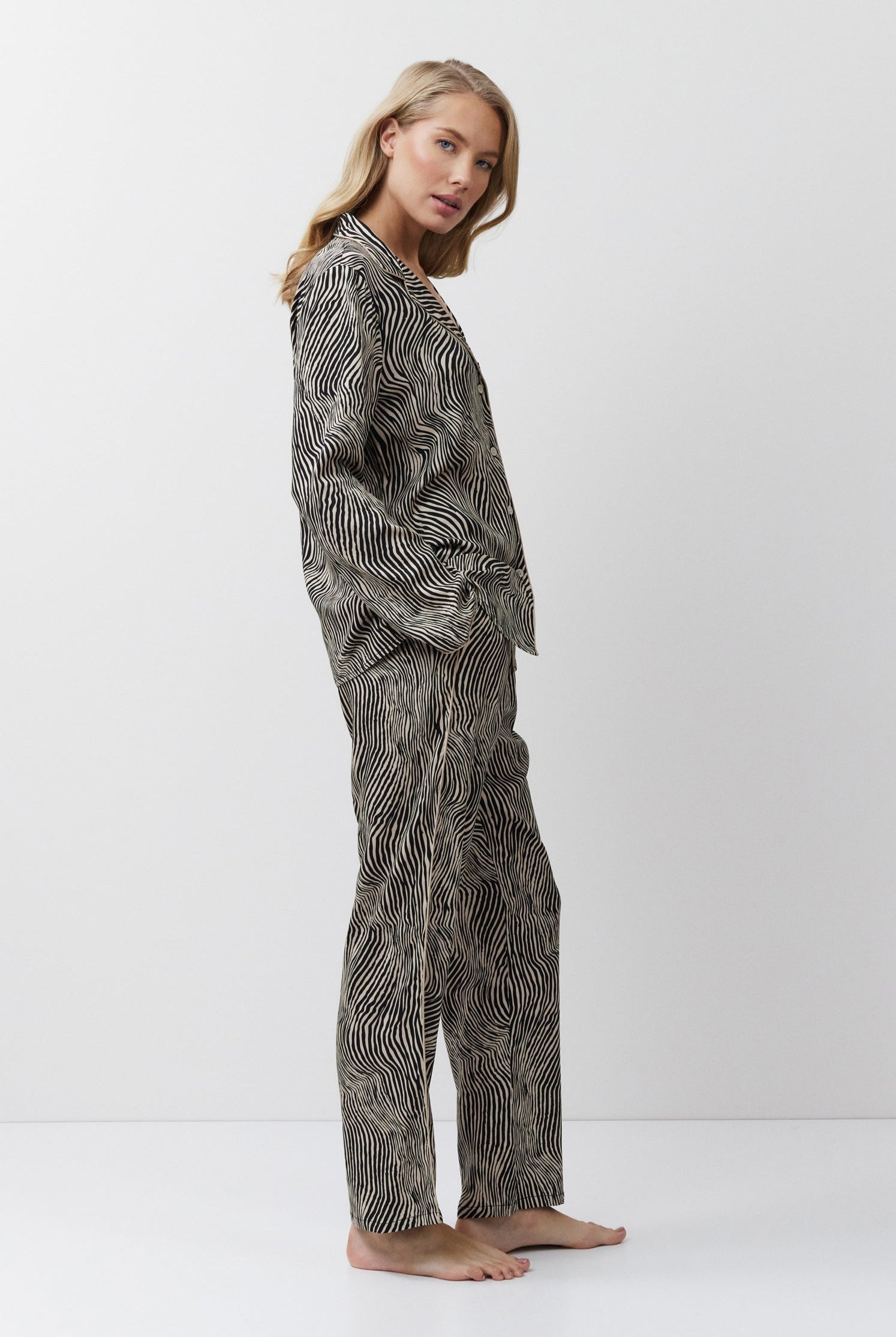 Woman wearing a patterned pajama set on a white background