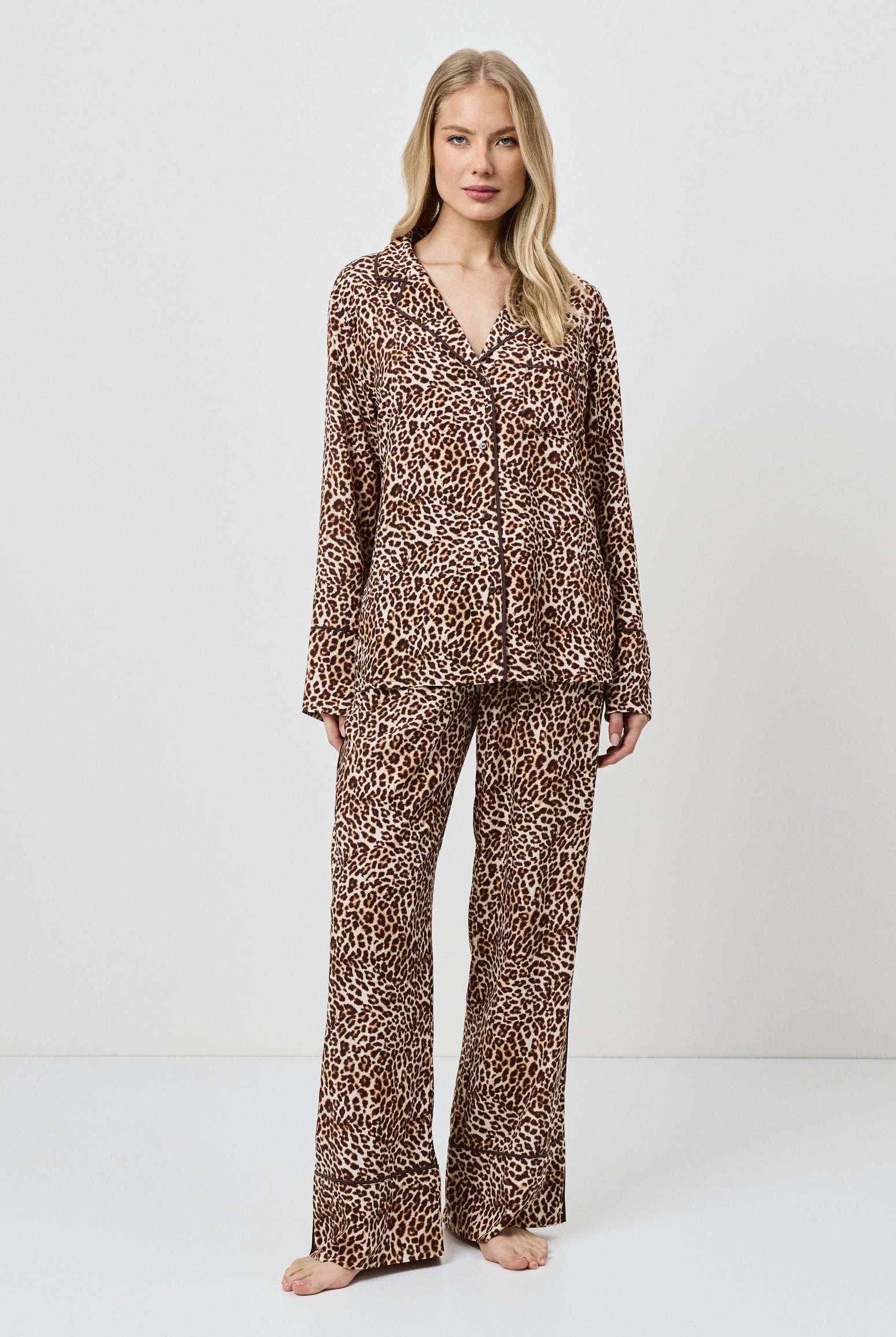 Woman wearing a leopard print pajama set on a white background