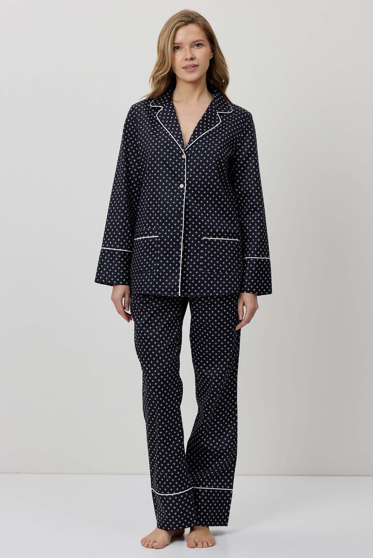 Woman wearing a black polka dot pajama set on a white background