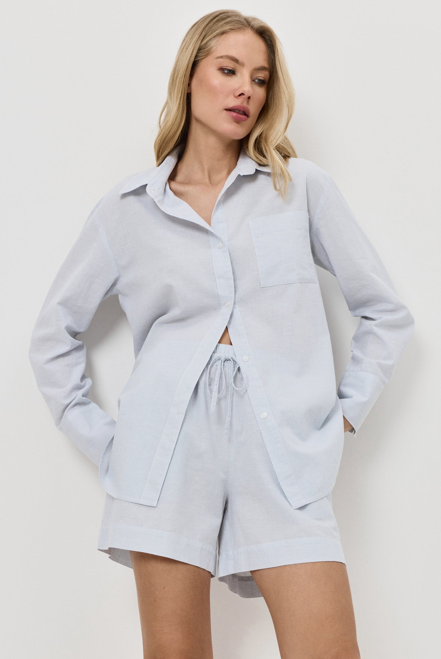 Woman wearing a light blue resort wear set on a white background