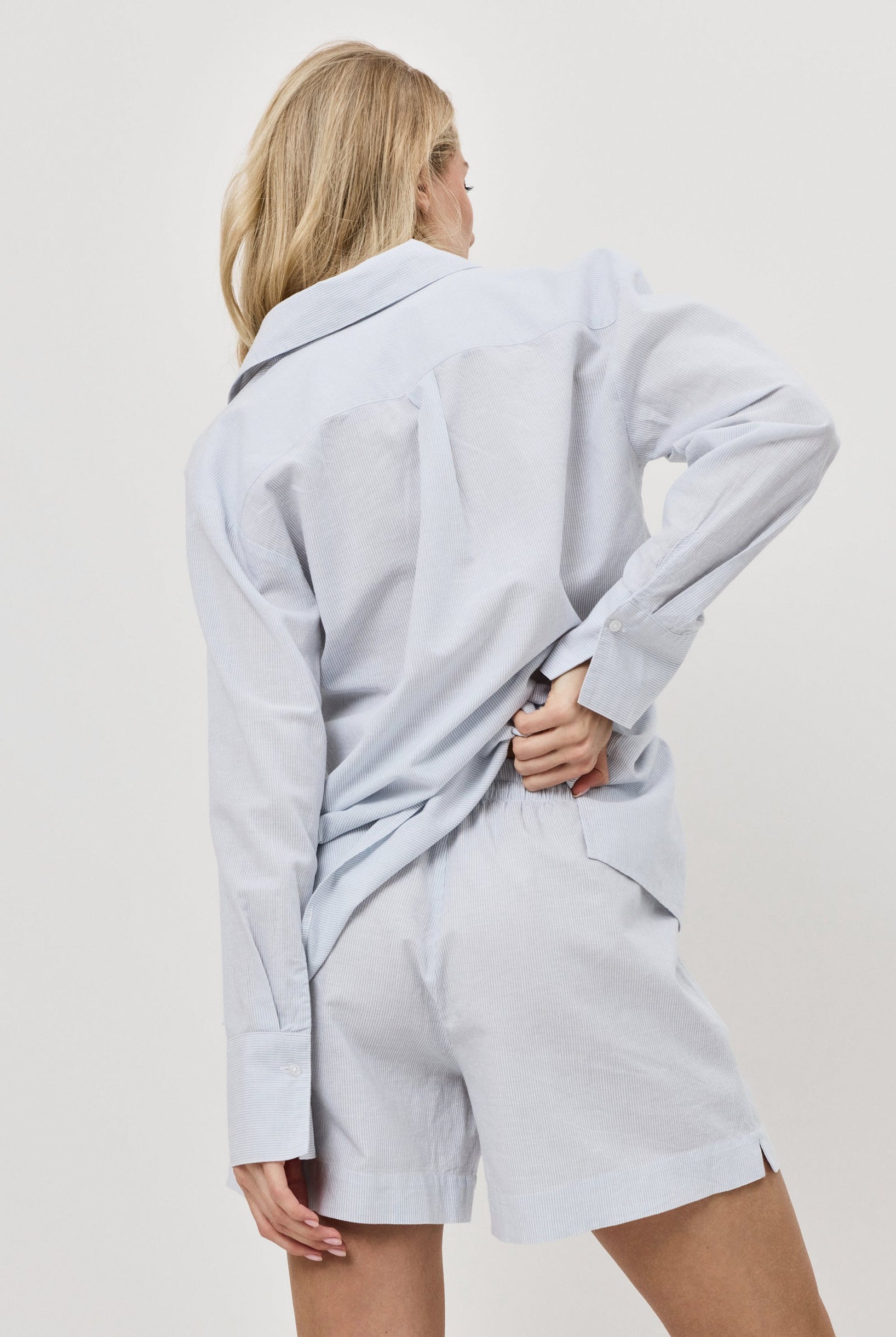 Person wearing a light blue resort wear set a plain background