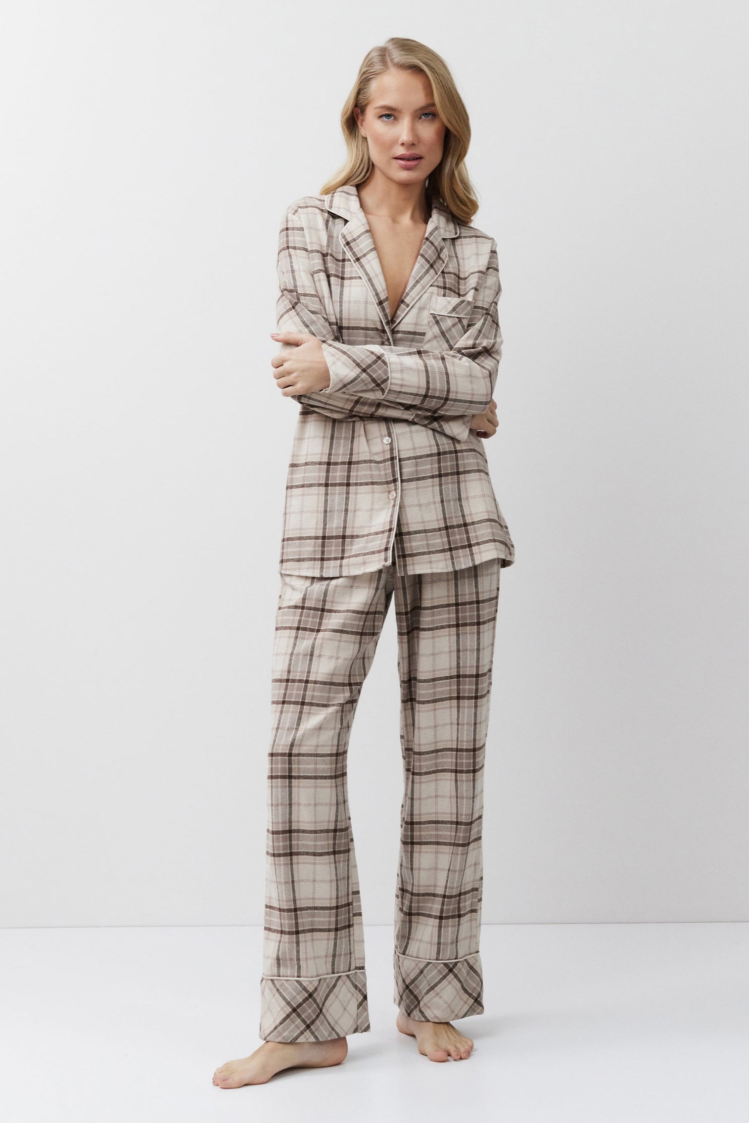 Woman wearing a plaid pajama set on a white background