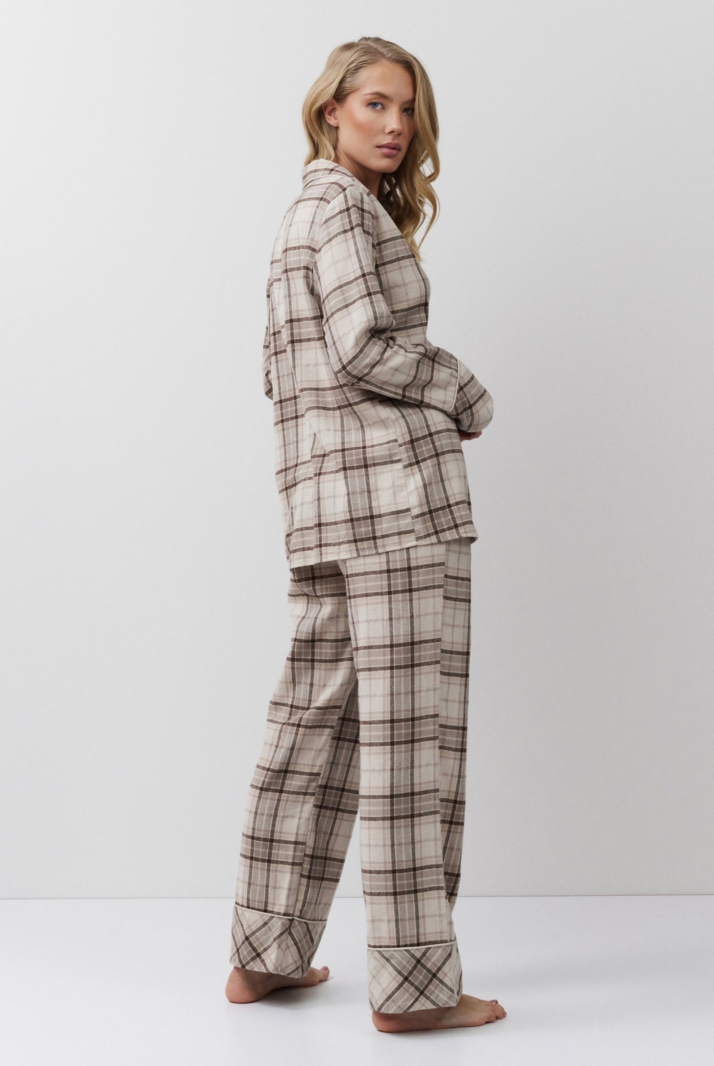 Person wearing a plaid pajama set on a white background