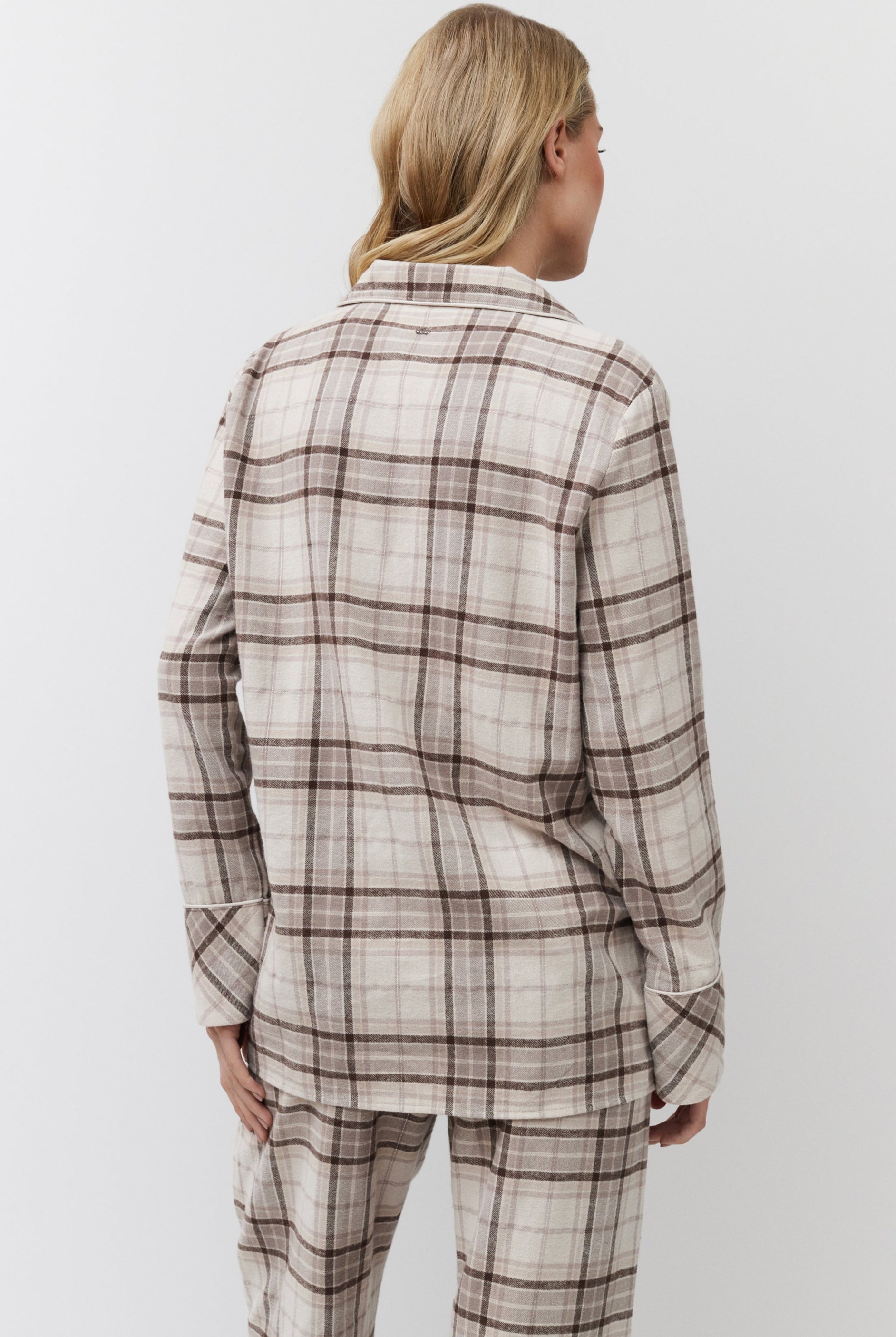 Person wearing a plaid shirt and pants on a white background