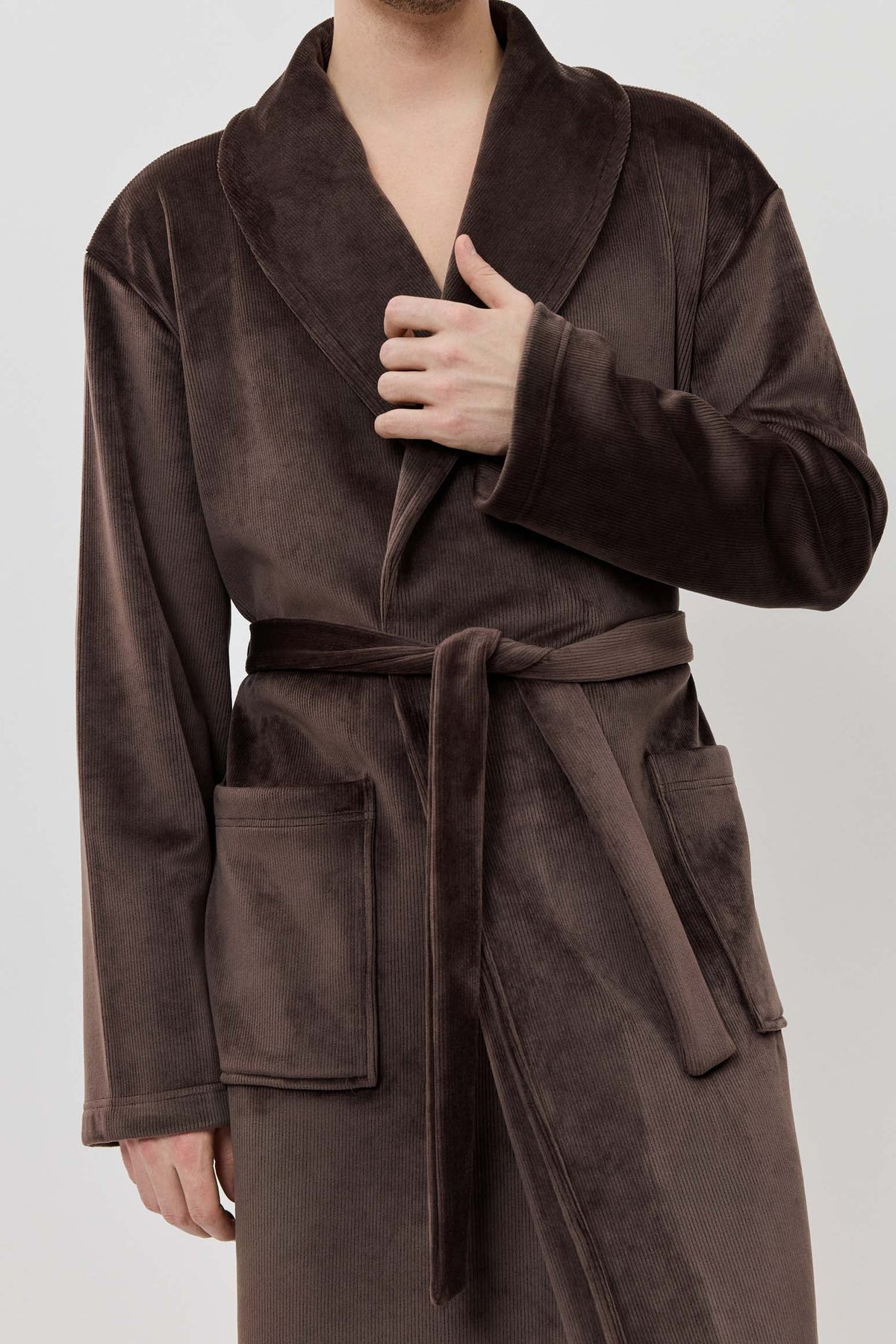 Man wearing a brown robe against a white background