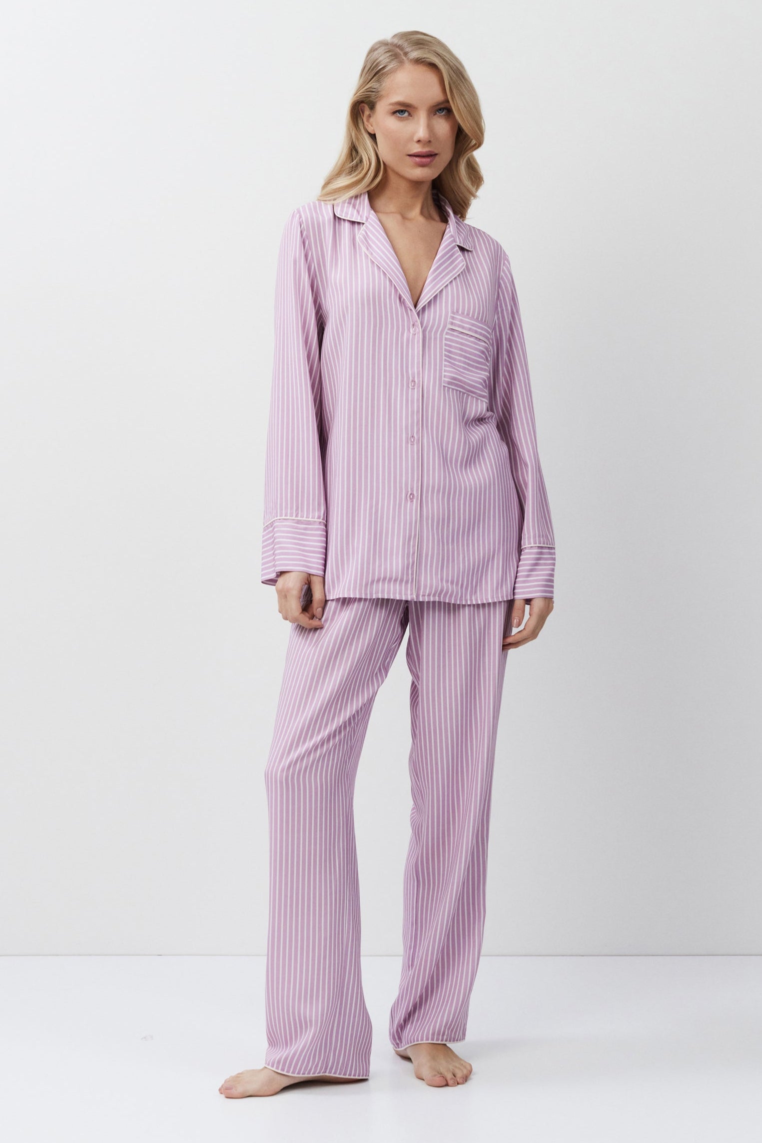 Woman wearing a lilac striped pajama set on a white background