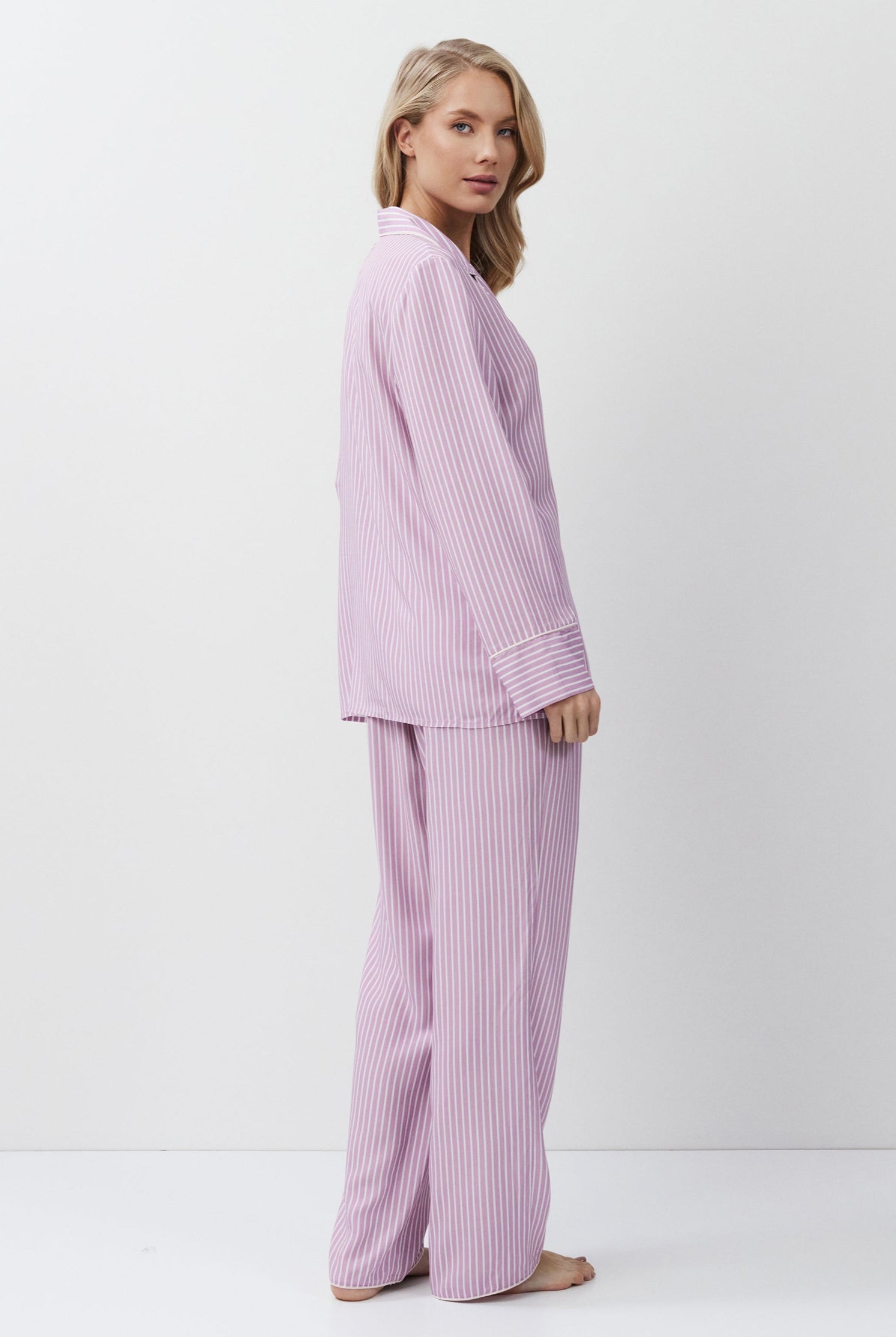 Woman wearing a light purple pajama set on a white background