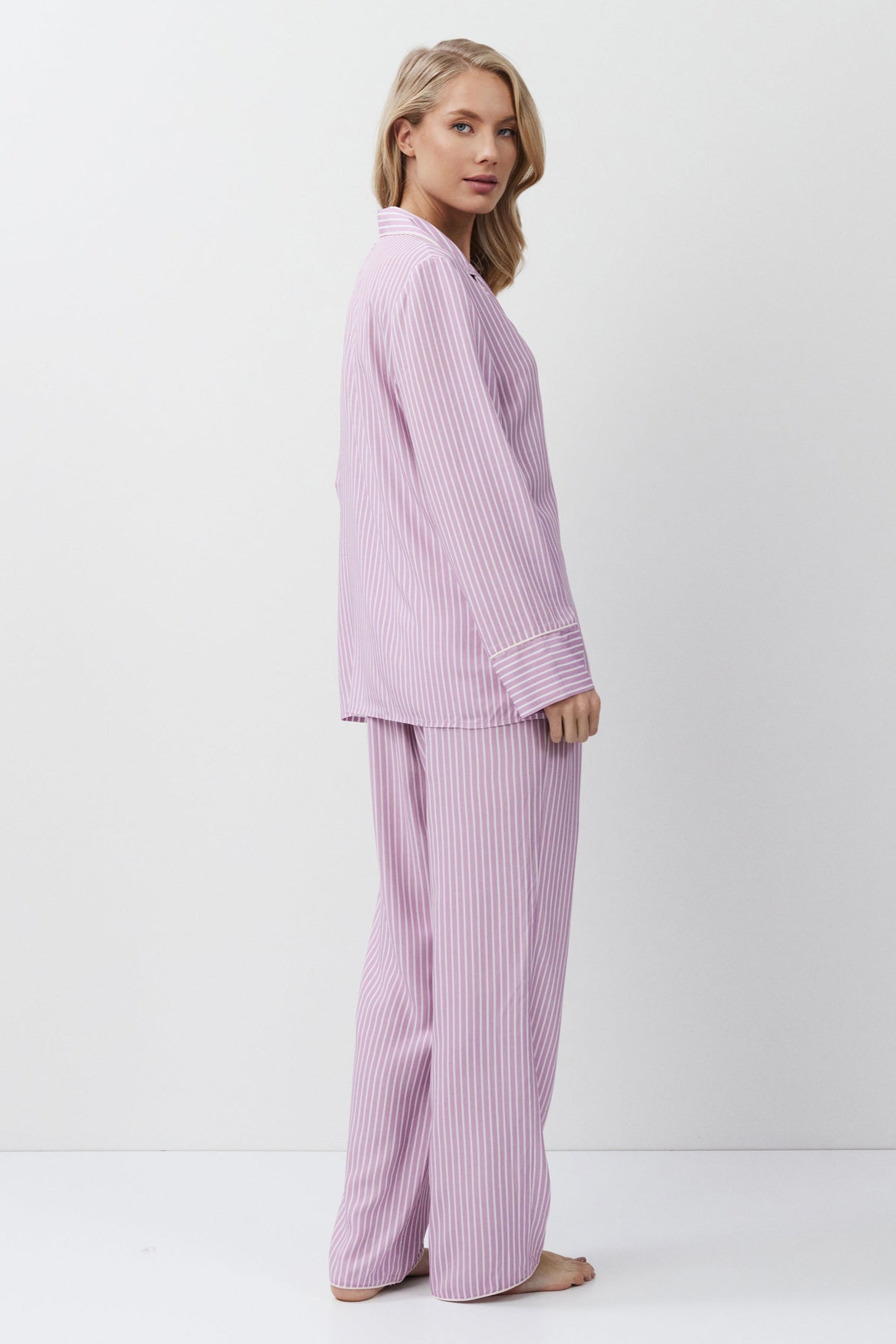 Woman wearing a light purple pajama set on a white background