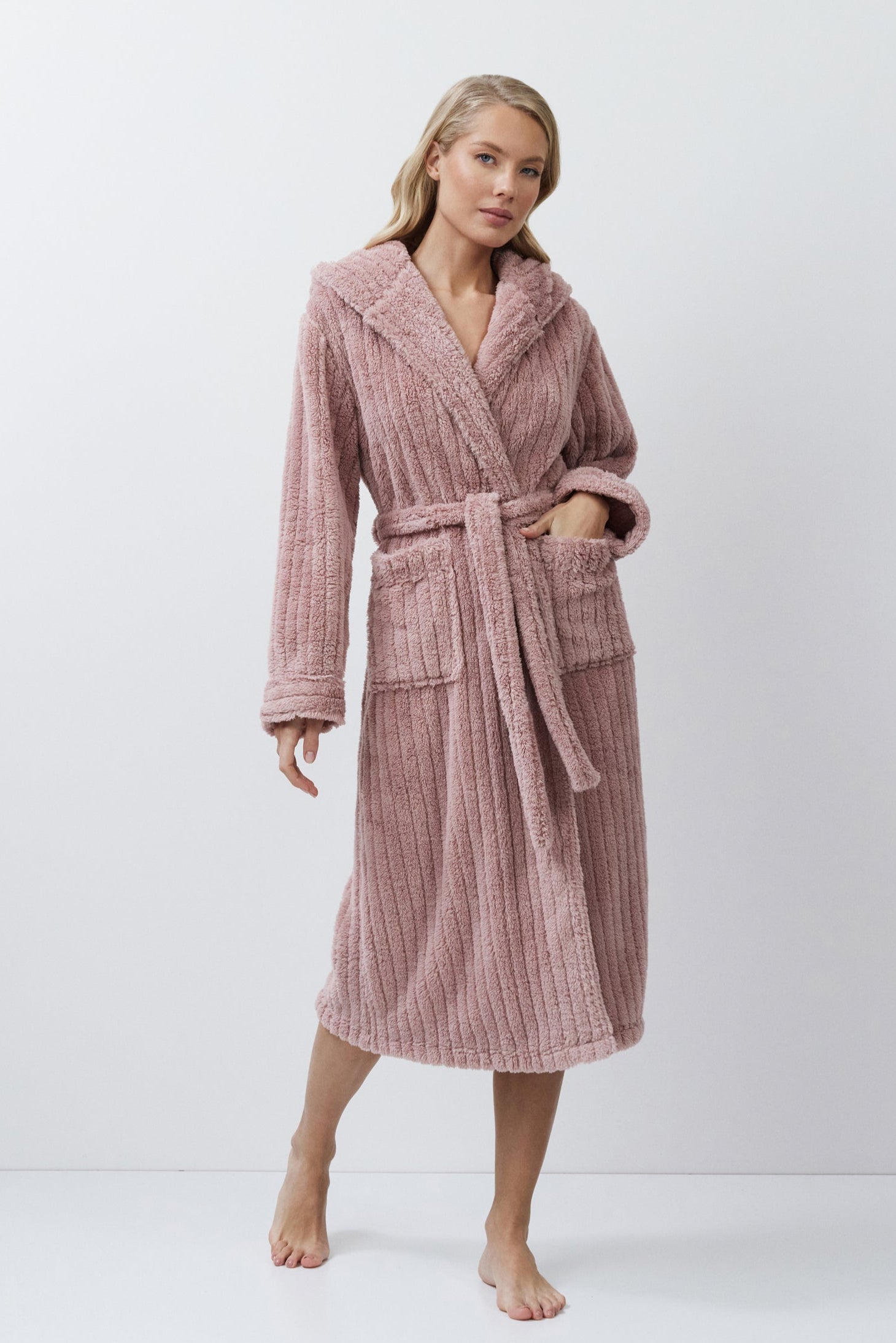 Woman wearing a pink textured bathrobe on a white background