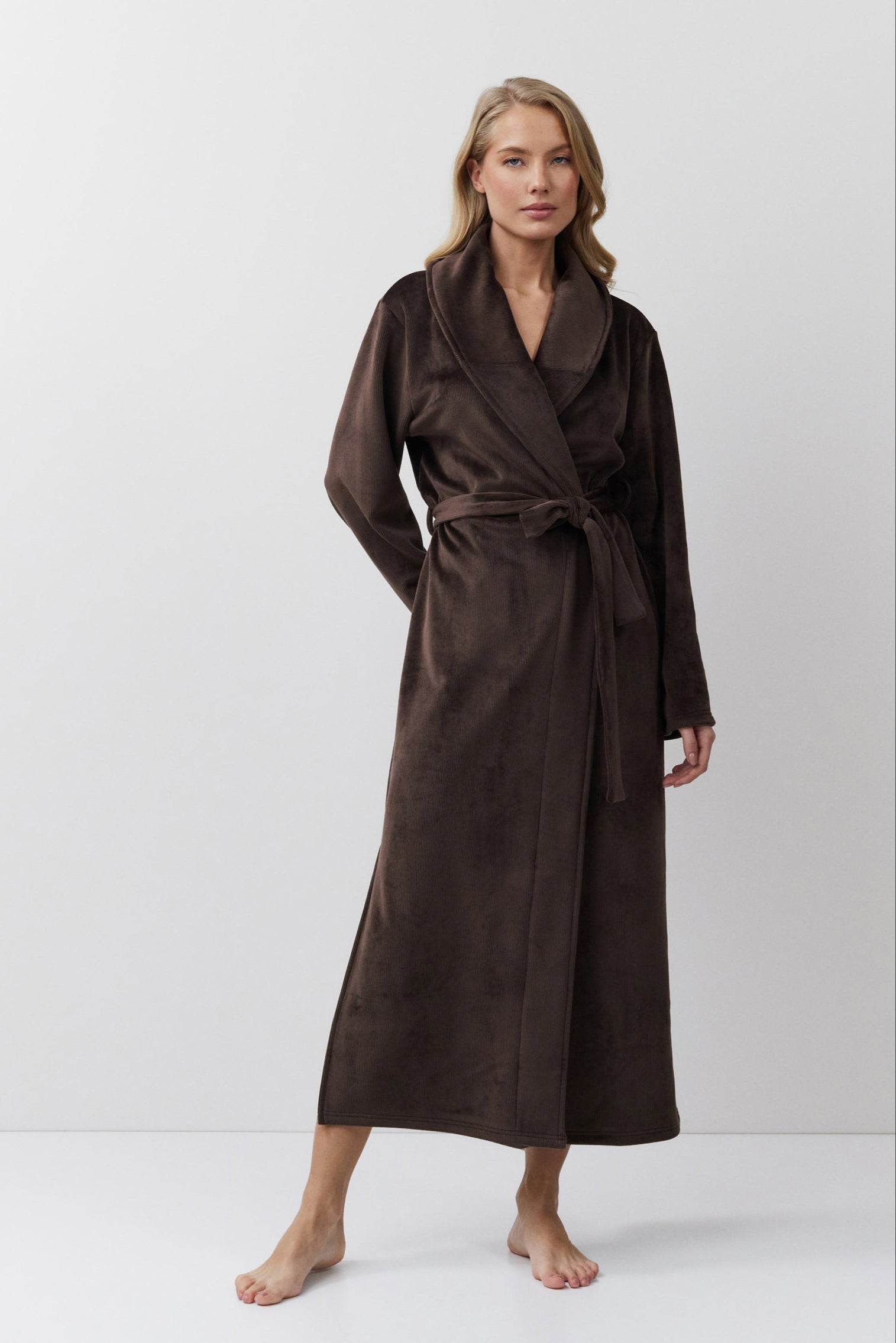 Woman wearing a brown bathrobe against a white background