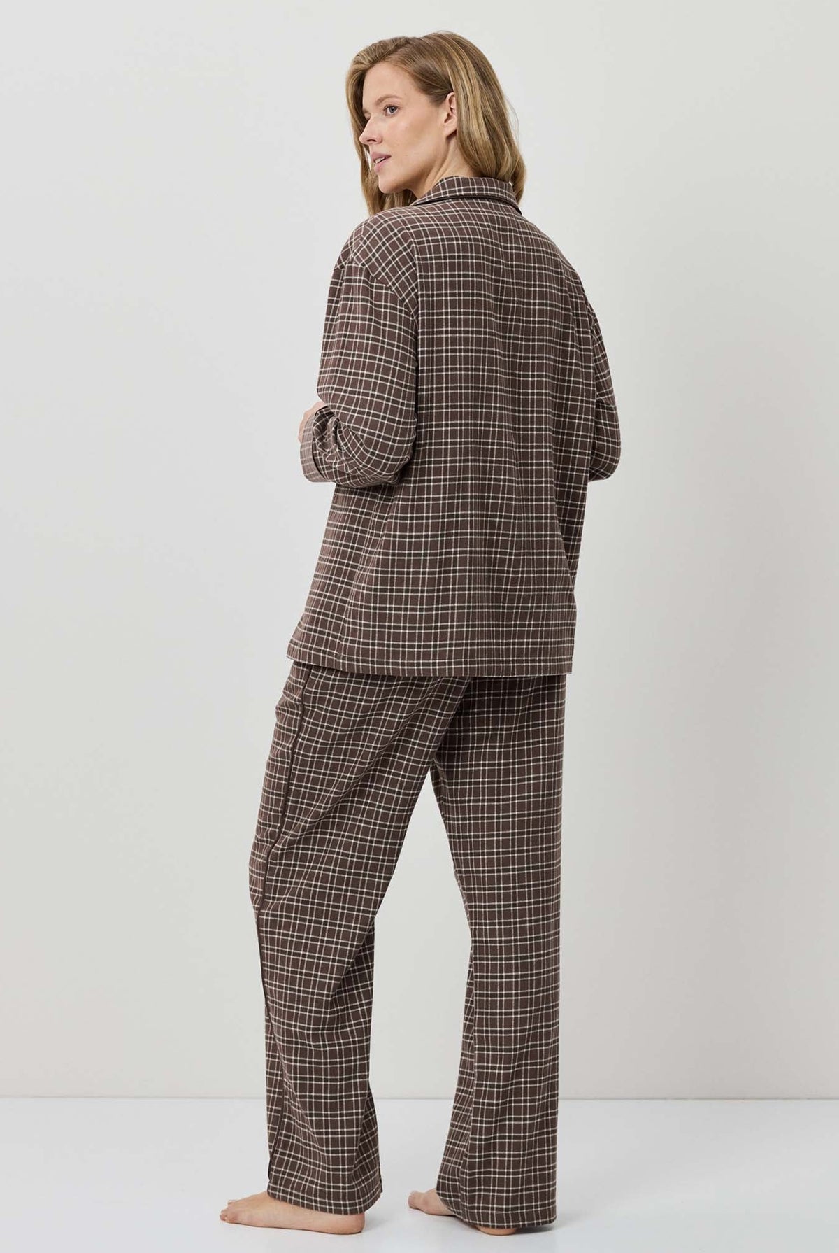 Person wearing a brown plaid suit on a white background