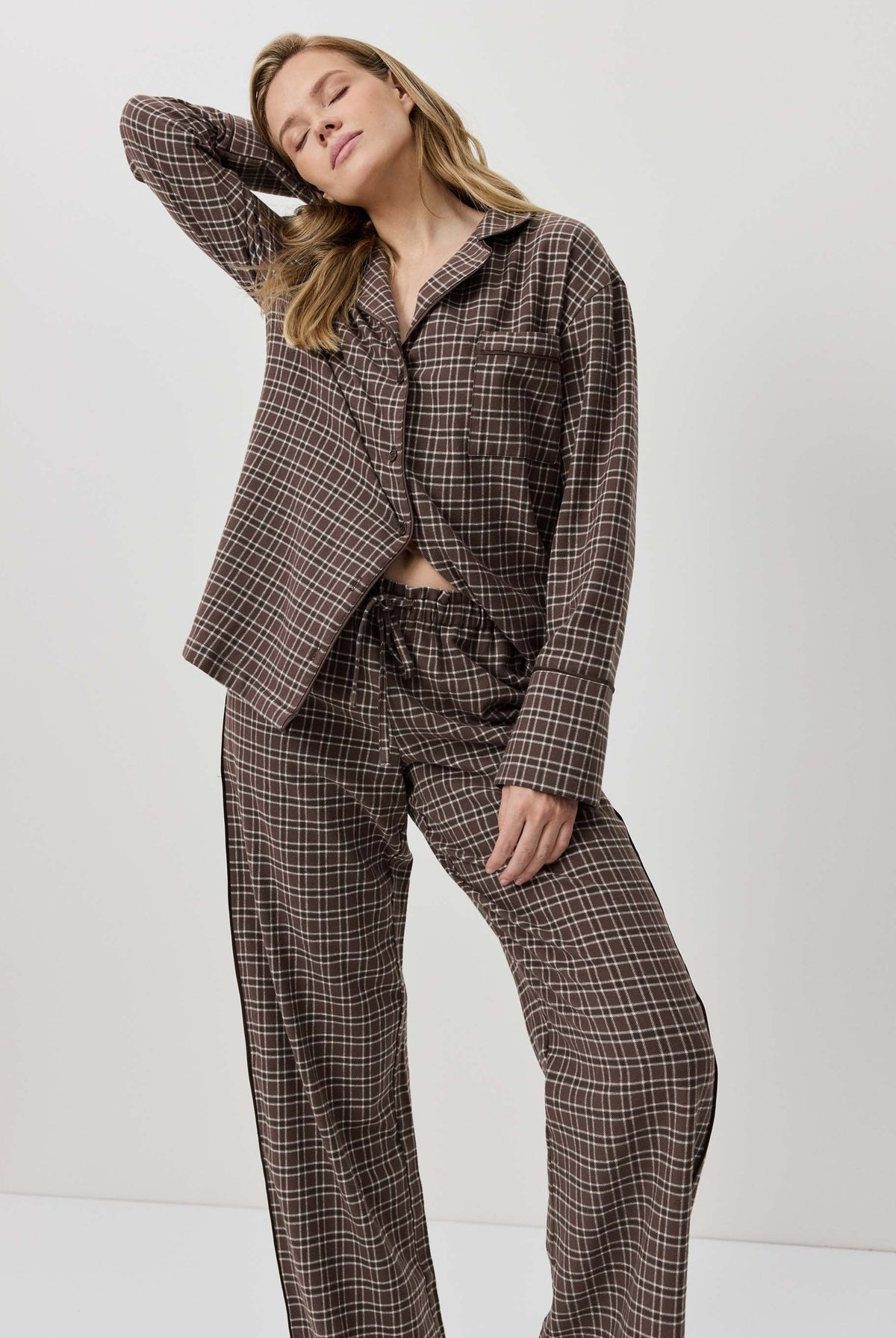 Woman wearing a brown plaid suit against a white background